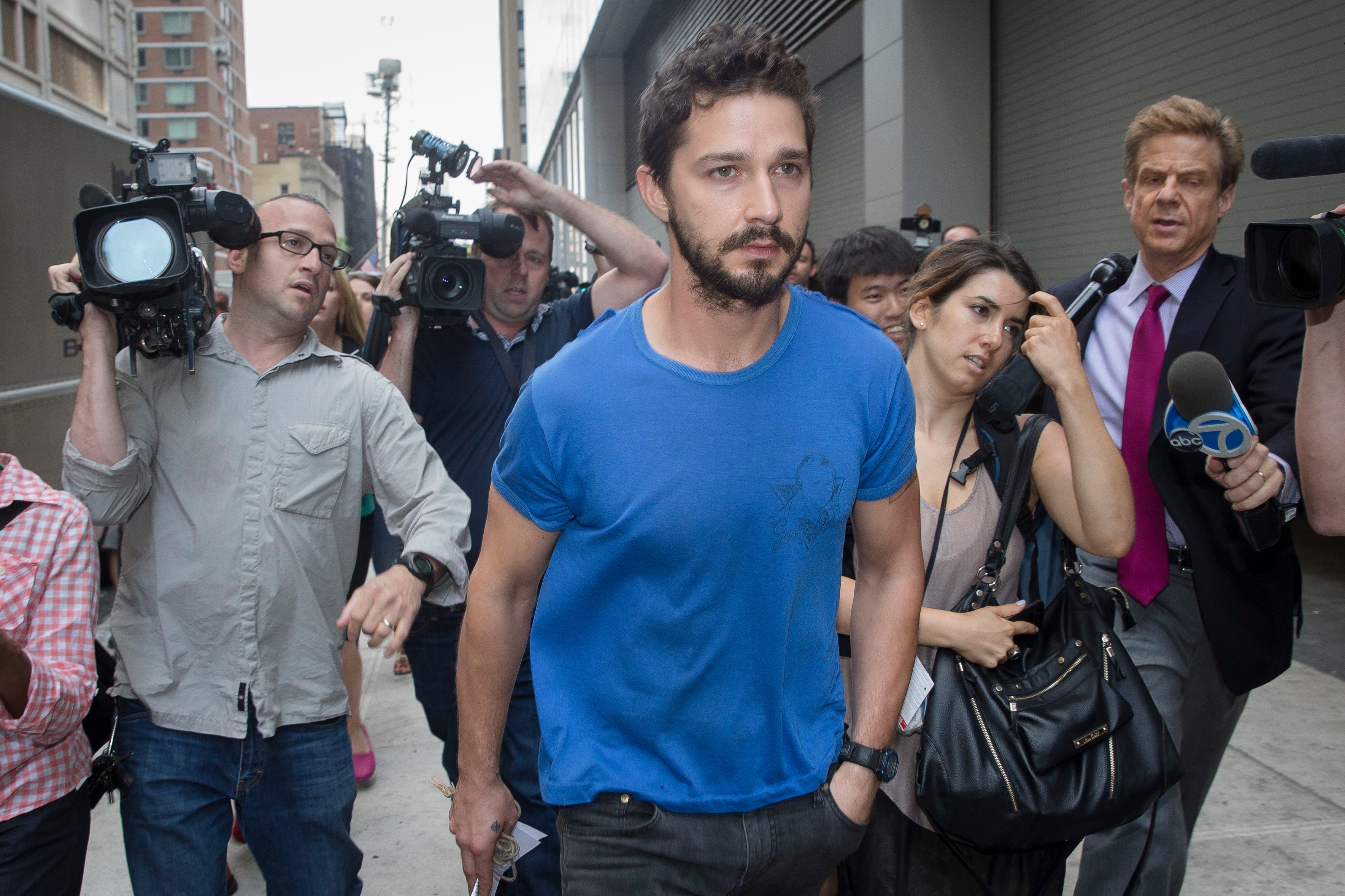Actor Shia LaBeouf walks through the media after leaving Midtown Community Court following his arrest the previous day for yelling obscenities at the Broadway show "Cabaret," Friday, June 27, 2014, in New York. The 28-year-old star of the "Transformers" franchise faces charges that include disorderly conduct and criminal trespass.  (AP Photo/John Minchillo)