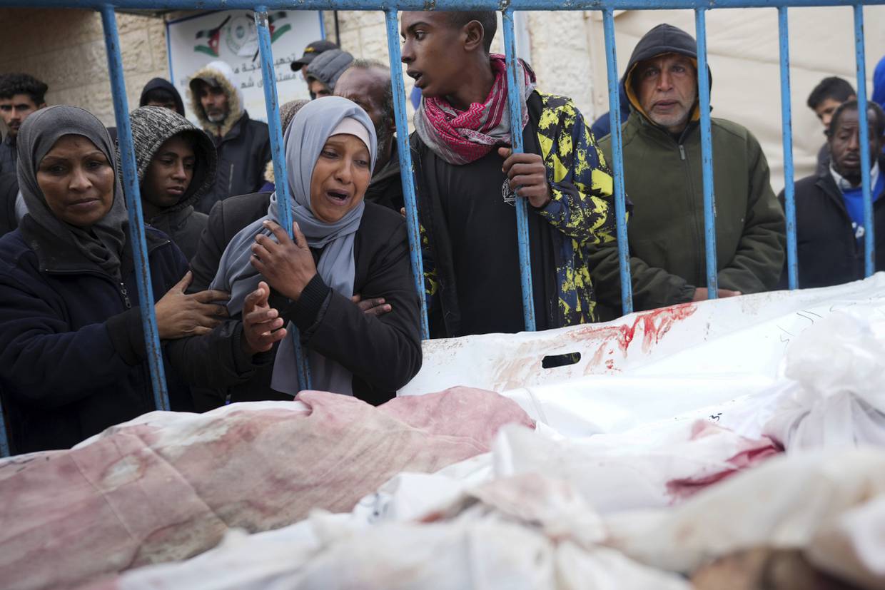 Palestinos lloran a sus familiares muertos en la ofensiva israelí por tierra y aire en la Franja de Gaza, el viernes 26 de enero de 2024, en un hospital de Deir al Balah. (AP Foto/Adel Hana)