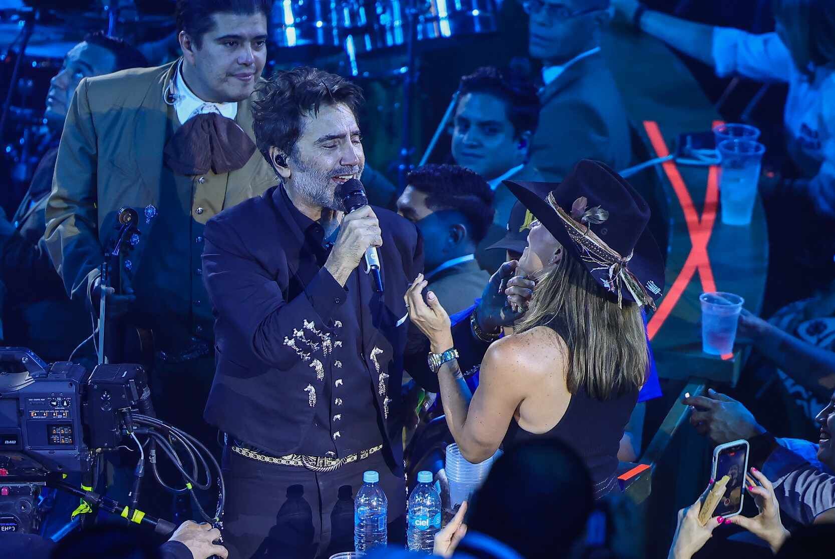 Alejandro Fernández sostiene la cara de una mujer asistente a su concierto mientras le canta. | Eleazar Escobar.