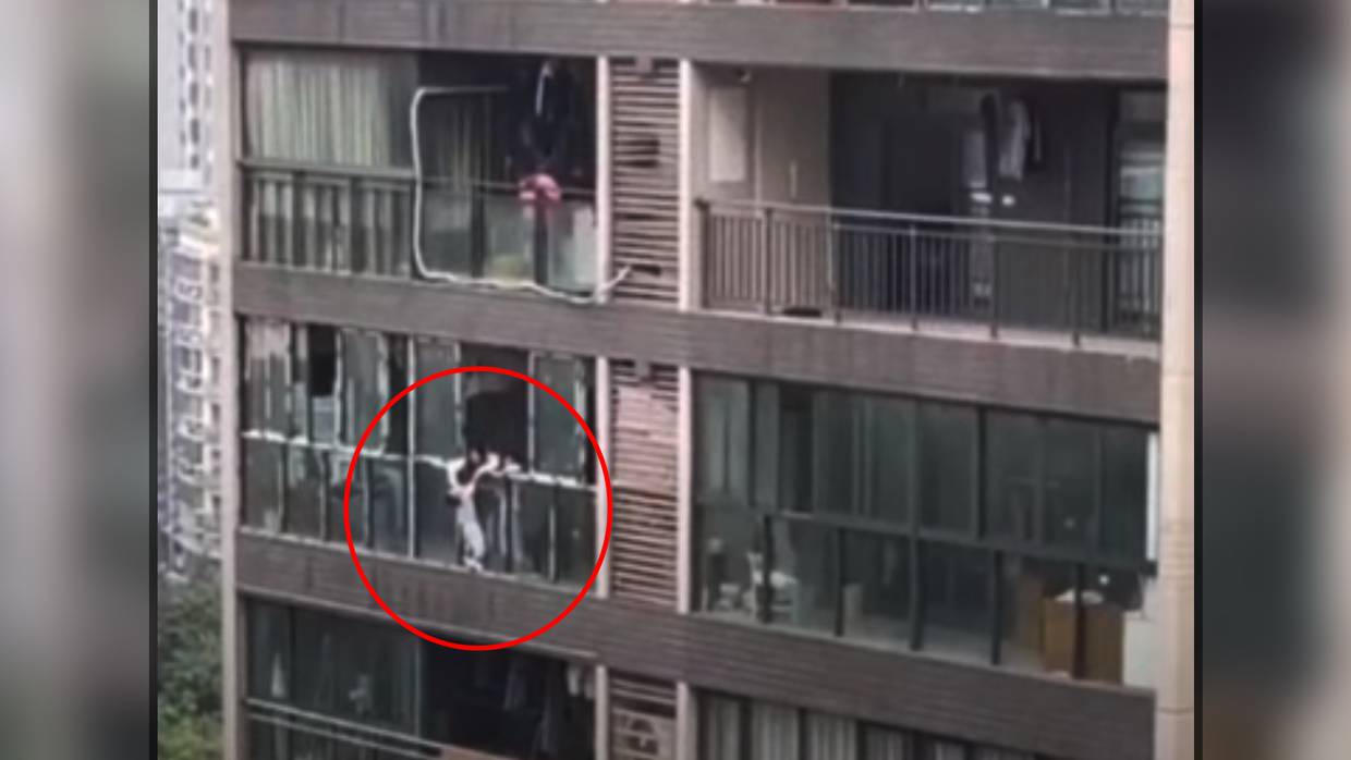 La madre sostiene a su hijo de 3 años desde el balcón de su apartamento en el piso 22 de un edificio momentos antes de arrojarlo directo a su muerte.