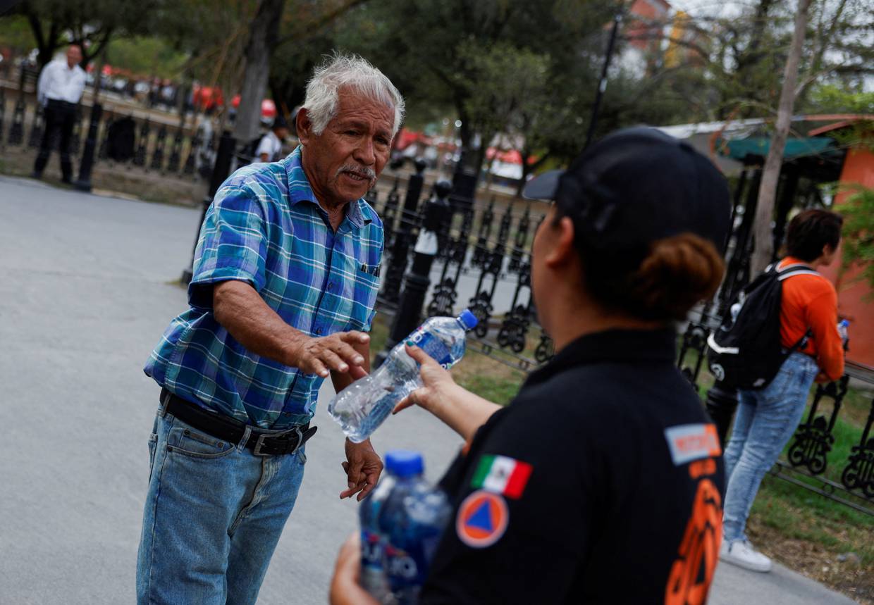 Imagen de archivo. Miembros de Protección Civil entregan botellas de agua fría durante una ola de calor, en Monterrey, México, 9 de mayo de 2024. REUTERS/Daniel Becerril
