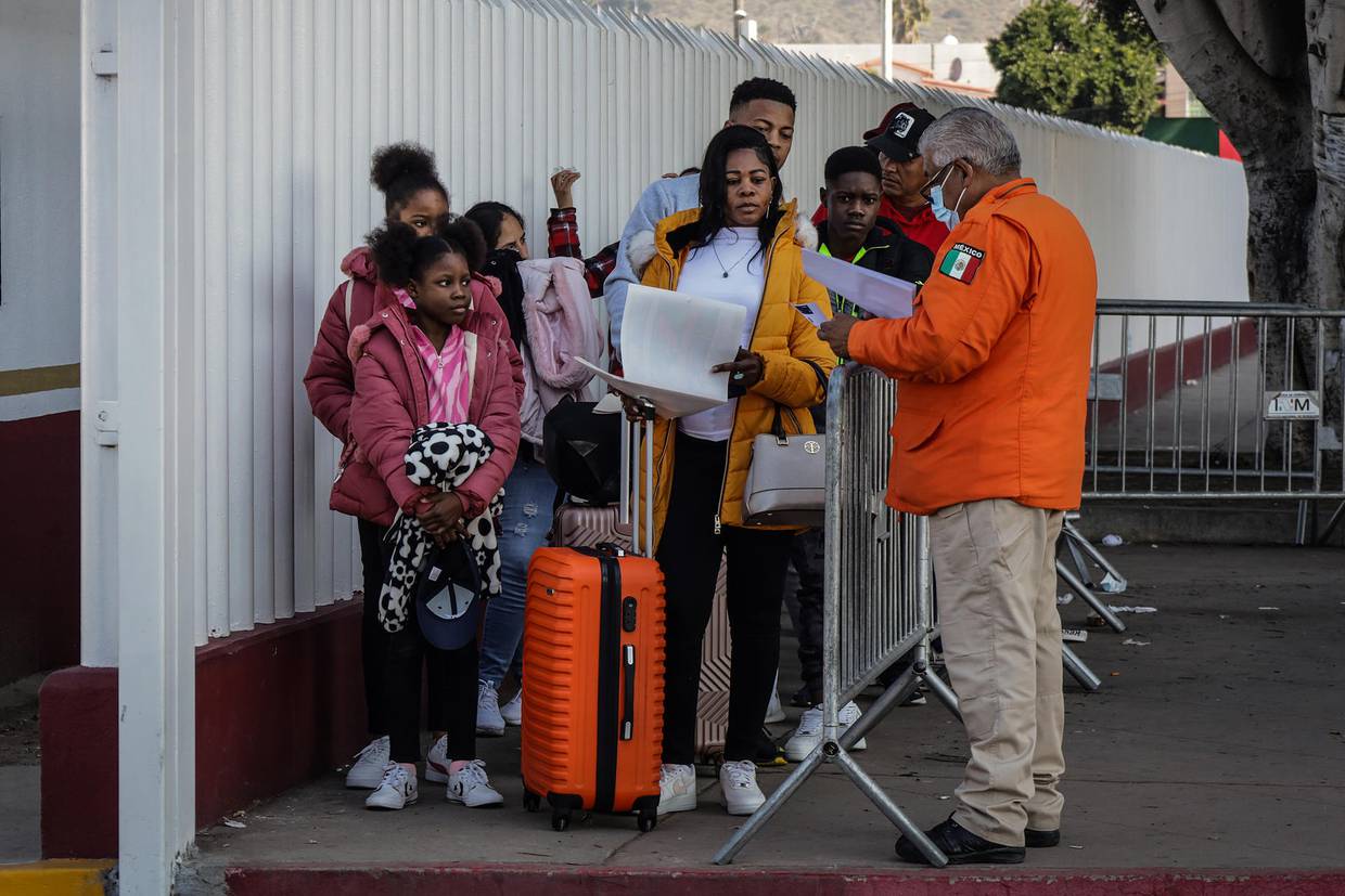Migrantes hacen fila para solicitar un proceso de asilo en Estados Unidos, el 25 de enero de 2024 en el paso fronterizo del Chaparral en Baja California (México). EFE/Joebeth Terríquez