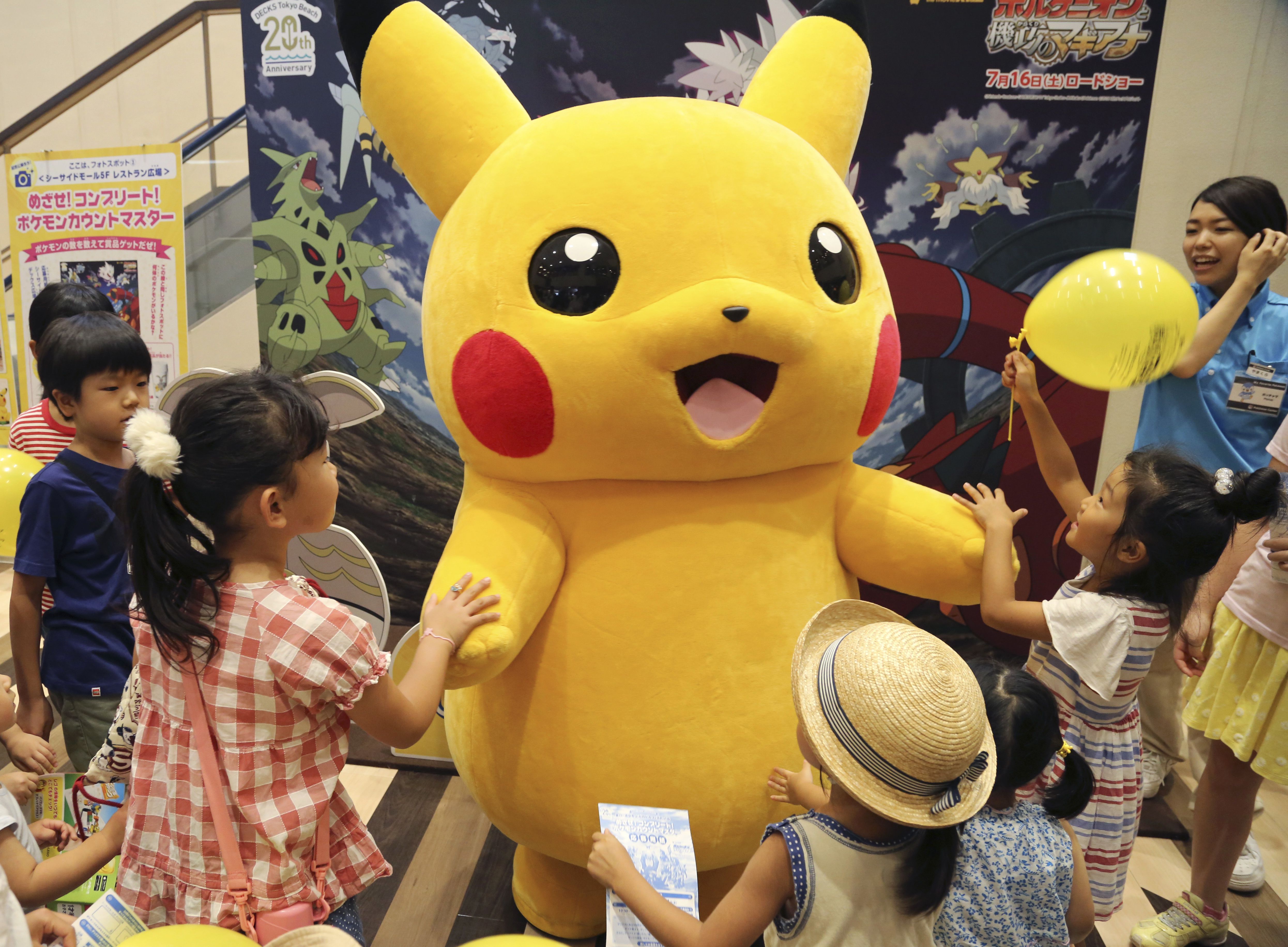 FILE - In this July 18, 2016, file photo, a stuffed toy of Pikachu, a Pokemon character, is surrounded by children during a Pokemon festival in Tokyo. A real-life Pikachu statue appeared in a New Orleans park. New Orleans police told ABC News for a story published August 2, 2016, that they have no plans to remove it. (AP Photo/Koji Sasahara, File)