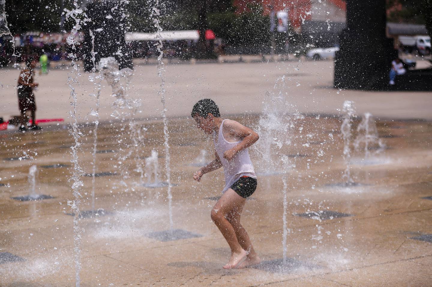 Un niño juega con el agua en una fuente del Monumento a la Revolución en Ciudad de México (México). EFE/Isaac Esquivel
