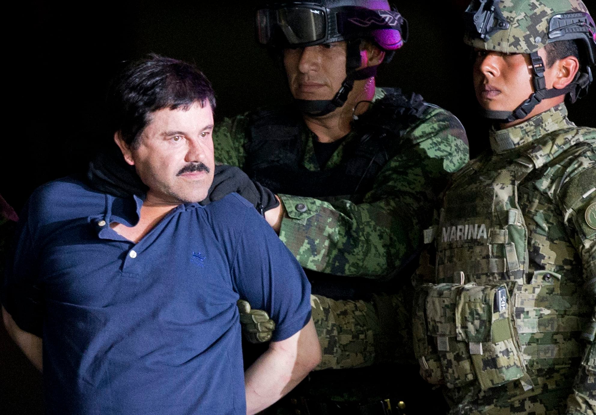 Joaquin "El Chapo" Guzman is made to face the press as he is escorted to a helicopter in handcuffs by Mexican soldiers and marines at a federal hangar in Mexico City, Mexico, Friday, Jan. 8, 2016. Mexican President Enrique Pena Nieto announced that Guzman had been recaptured six months after escaping from a maximum security prison. (AP Photo/Eduardo Verdugo)