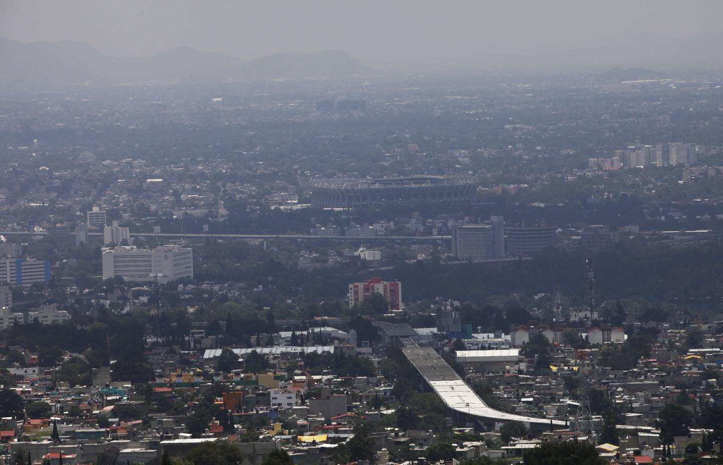 La contaminación del aire se cierne sobre la Ciudad de México, el sábado 9 de julio de 2016. Las autoridades emitieron una nueva alerta de smog para la capital después de que los niveles de ozono aumentaron a casi el doble de los límites aceptables. El Estadio Azteca está al fondo.(AP Photo/Marco Ugarte)