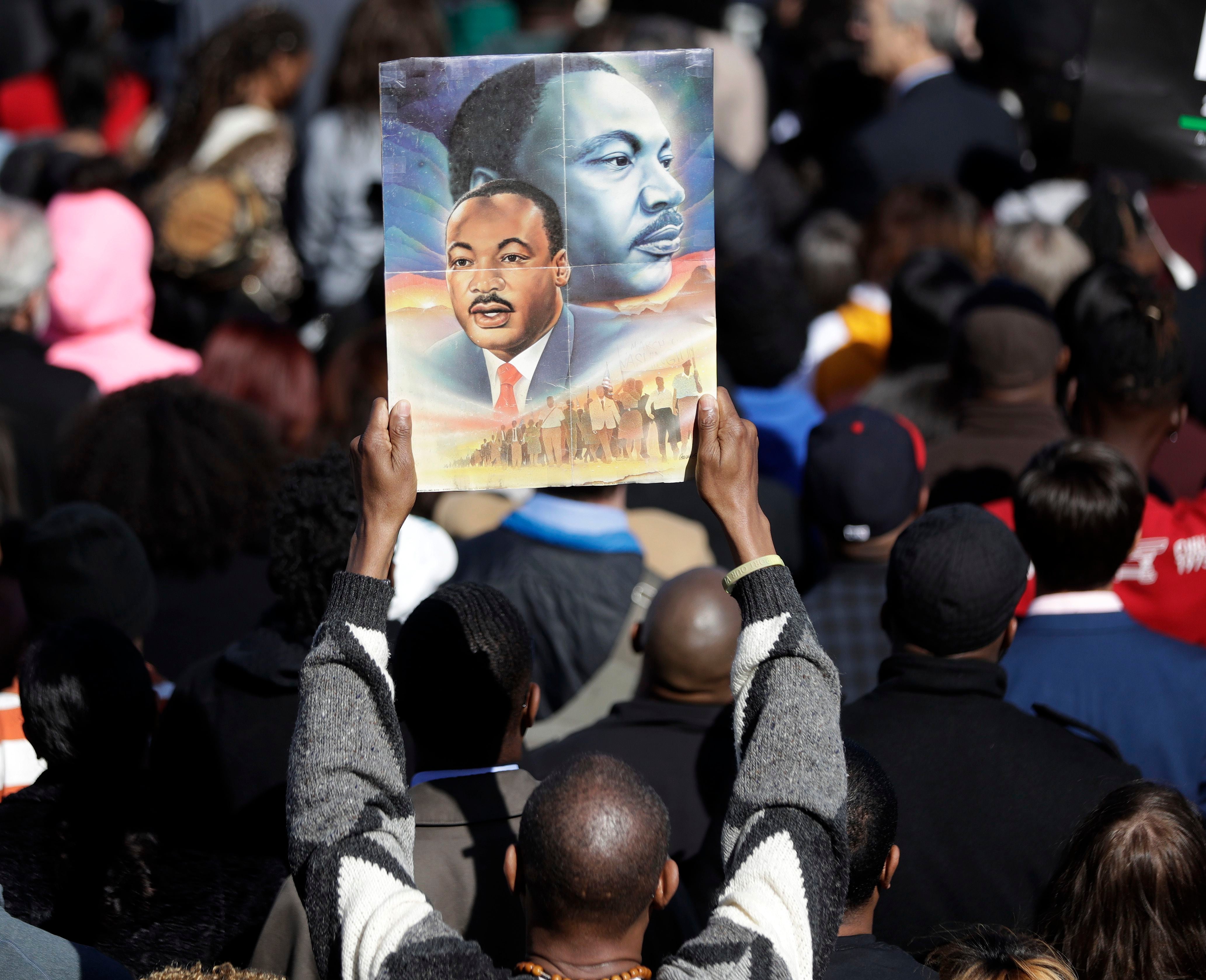 A man holds a poster of Rev. Martin Luther King Jr. as he attends activities at the National Civil Rights Museum, commemorating the 50th anniversary of King's assassination, Wednesday, April 4, 2018, in Memphis, Tenn. King was assassinated April 4, 1968, while in Memphis supporting striking sanitation workers. (AP Photo/Mark Humphrey)