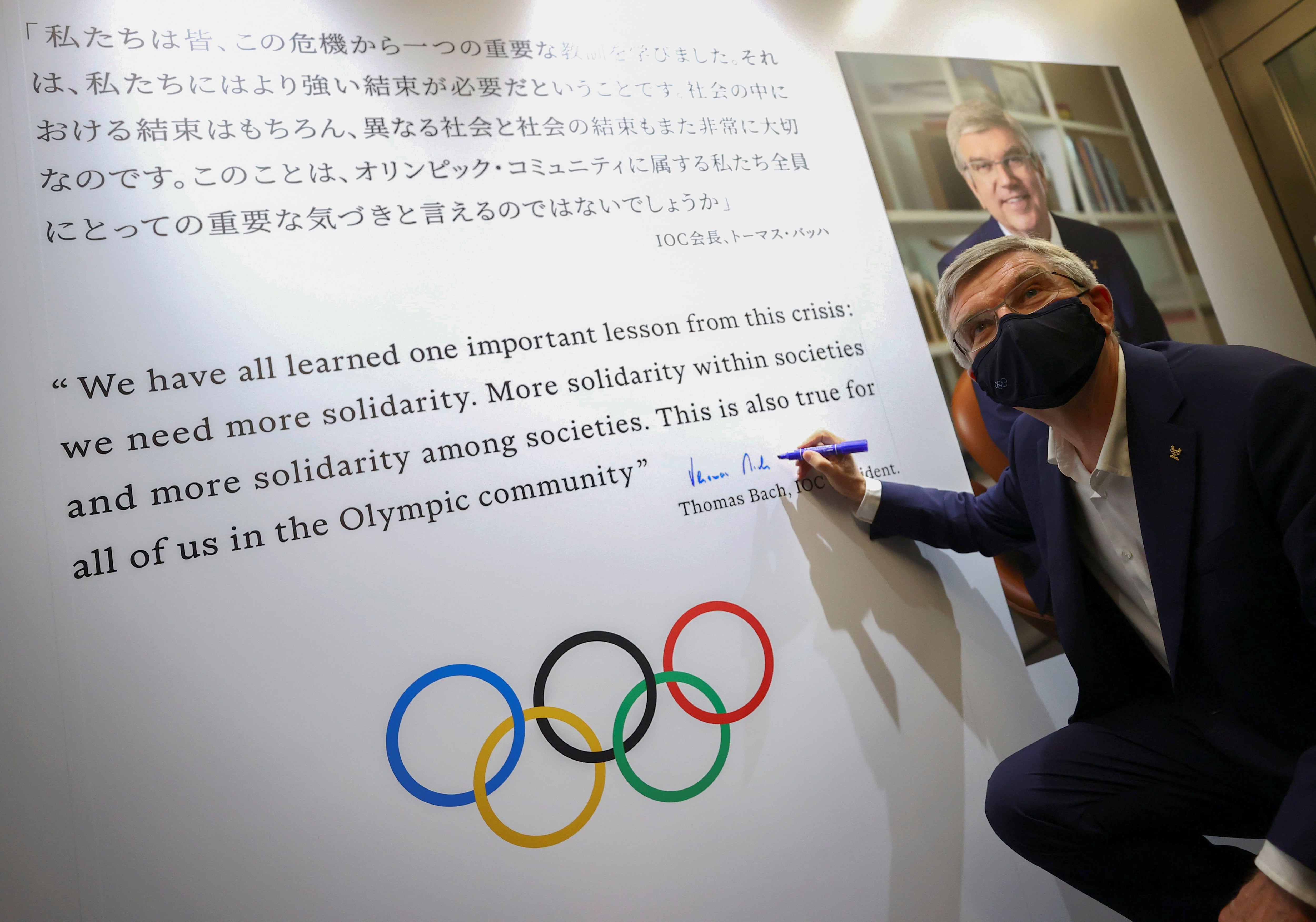 Foto del viernes del presidente del COI, Thomas Bach, autografiando un mural en una exhibición sobre la historia de los Juegos en Tokio. 
 Jul 30, 2021. REUTERS/Issei Kato/Pool