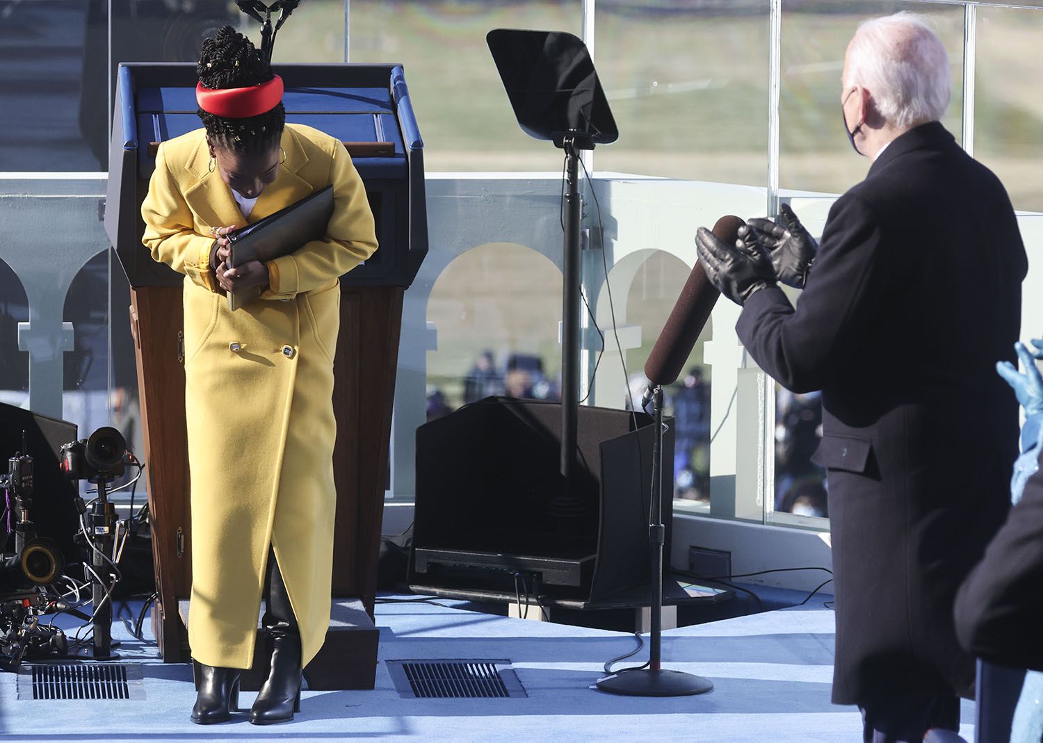 La poeta Amanda Gorman hace una reverencia al final de su presentación, mientras el presidente estadounidense Joe Biden aplaude, durante la ceremonia de investidura frente al Capitolio, en Washington, el miércoles 20 de enero del 2021. (Jonathan Ernst/Pool Photo via AP)