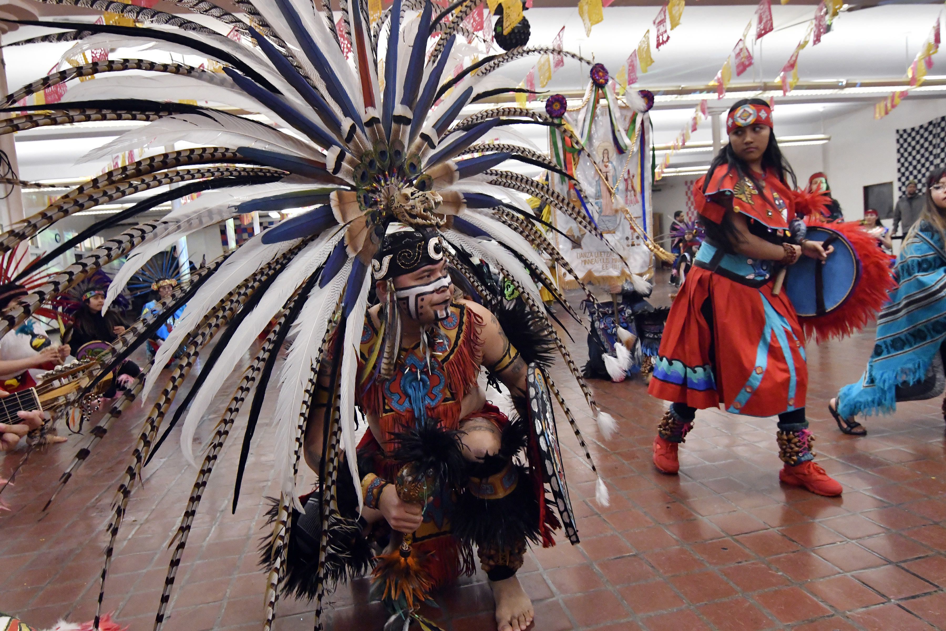 Personas con indumentarias aztecas bailan danzas típicas del sur de México durante los festejos en homenaje a San Pablo en Minneapolis el 24 de enero del 2020. San Pablo es el santo patrón de Axochipán, el pueblo de donde provienen muchos mexicanos de Minneapolis. (AP Photo/Jim Mone)