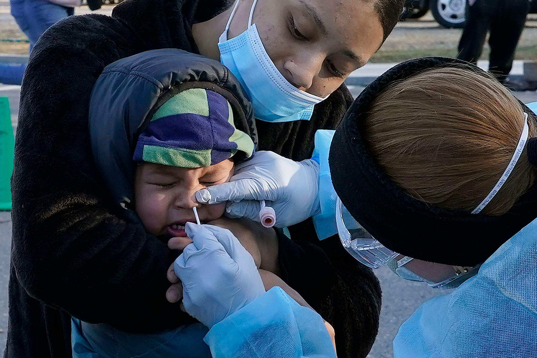 Jamillette Gomes sostiene a su hijo Avian, de 2 años, el 3 de diciembre de 2020 mientras le realizan la prueba del coronavirus, en Lawrence, Massachusetts. (AP Foto/Elise Amendola, archivo)