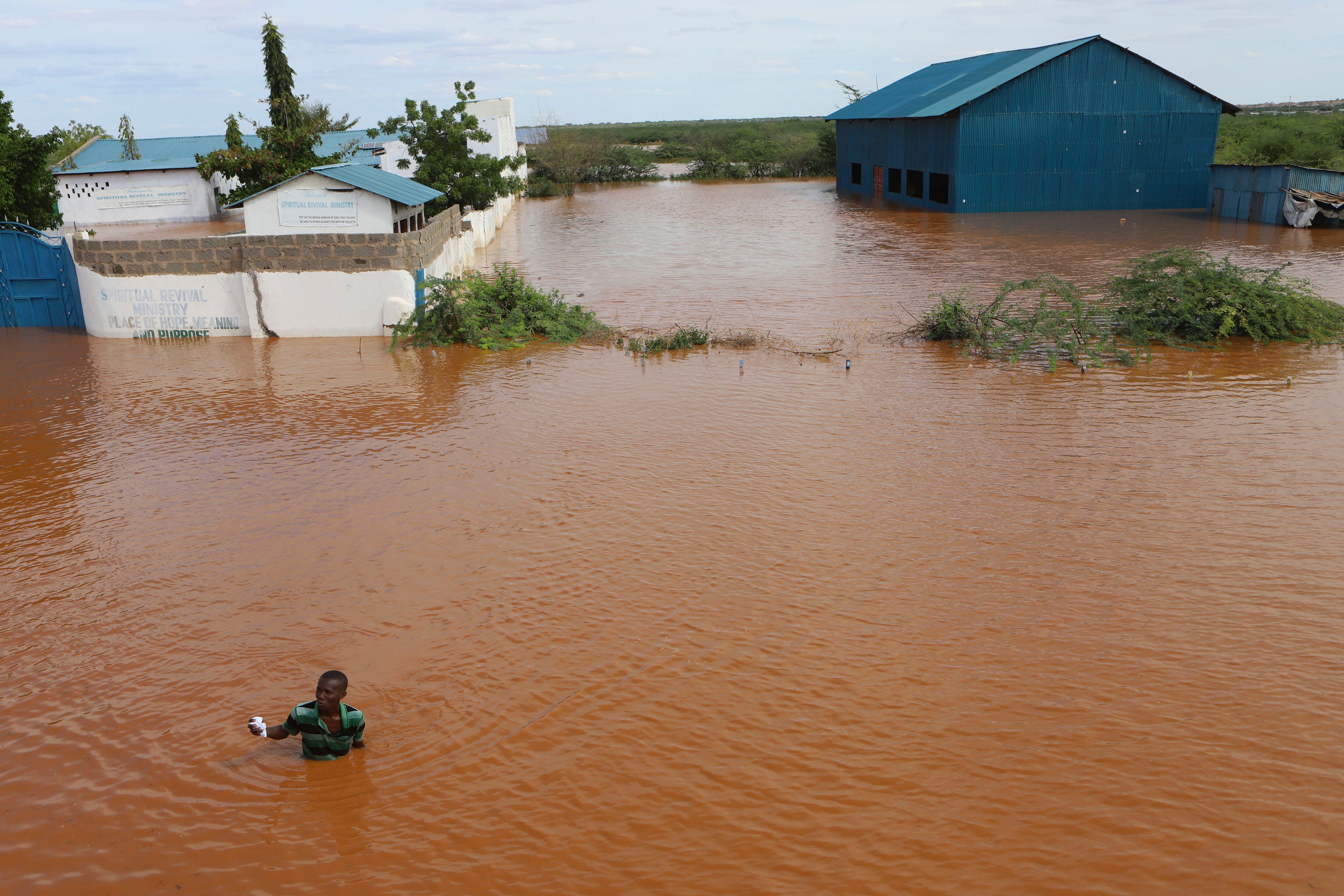 Un hombre nada desde el recinto anegado de una iglesia después de que el río Tana se desbordara en Mororo, en la frontera de los condados de Río Tana y Garissa, en el nordeste de Kenia, el domingo 28 de abril de 2024.  Las fuertes lluvias en distintas zonas de Kenia han provocado decenas de muertos y desplazado a decenas de miles de personas, según Naciones Unidas. (AP Foto/Andrew Kasuku)