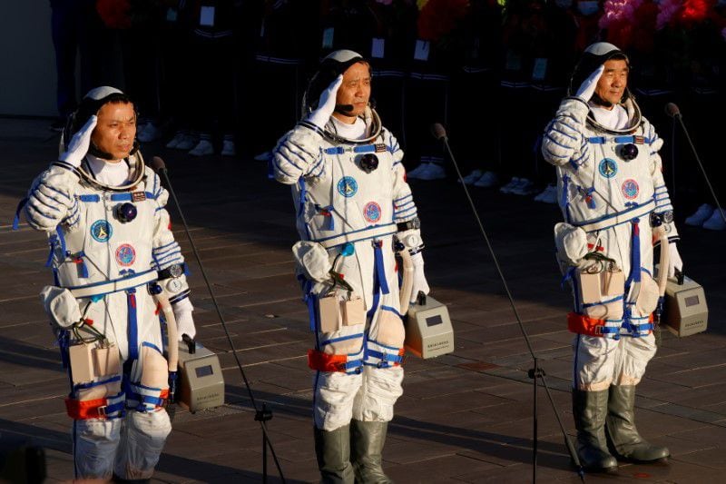 Los astronautas chinos Tang Hongbo, Nie Haisheng y Liu Boming saludan antes del lanzamiento del cohete Long March-2F Y12, que transporta la nave espacial Shenzhou-12 y los tres astronautas, desde el Centro de Lanzamiento de Satélites de Jiuquan para la primera misión tripulada de China para construir su estación espacial, cerca de Jiuquan, provincia de Gansu, China. 17 de junio de 2021. REUTERS/Carlos García Rawlins