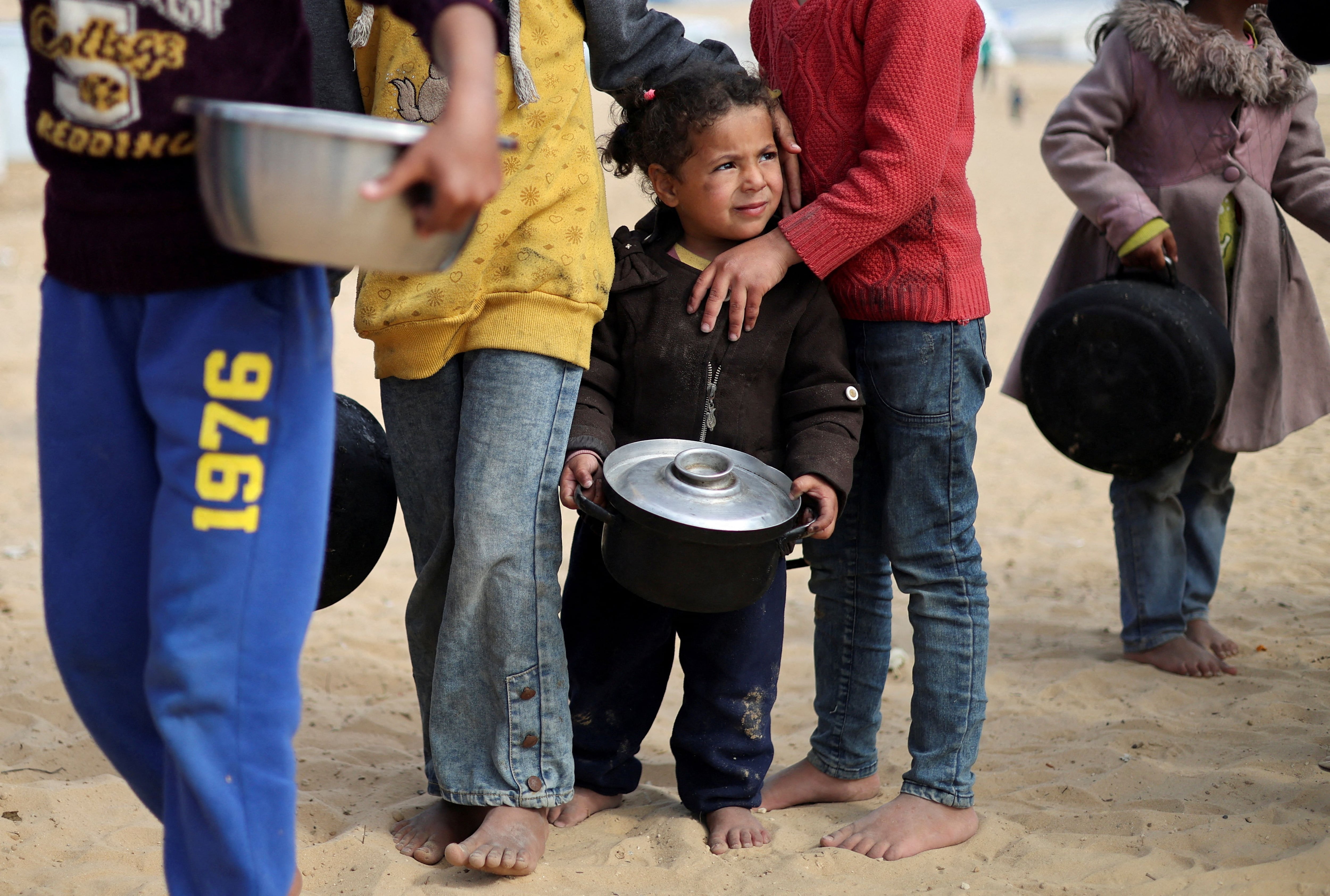 FOTO DE ARCHIVO: Niños palestinos desplazados esperan para recibir comida gratis en un campamento de tiendas de campaña, en medio de la escasez de alimentos. 27 de febrero de 2024. REUTERS/Ibraheem Abu Mustafa/File Photo
