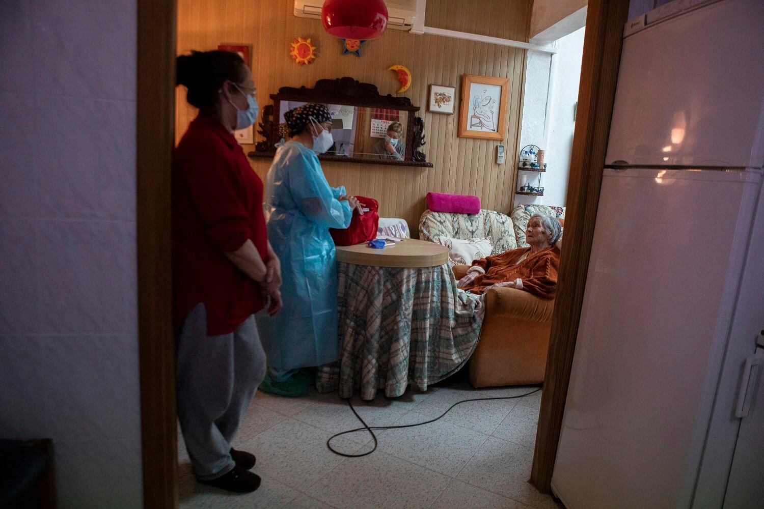 La enfermera Pilar Rodríguez habla con su paciente, Antonia Crespi Gomila, tras administrale la vacuna contra el COVID-19 en su casa en la localidad de Sa Pobla, en la isla española de Mallorca, el 30 de abril de 2021. (AP Foto/Francisco Ubilla)