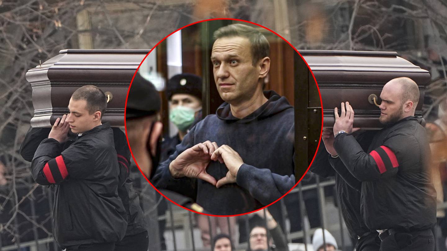 Alexei Navalny hace un corazón con sus manos desde el espacio reservado para los acusados durante una vista en el tribunal, en Moscú, Rusia.  | AP