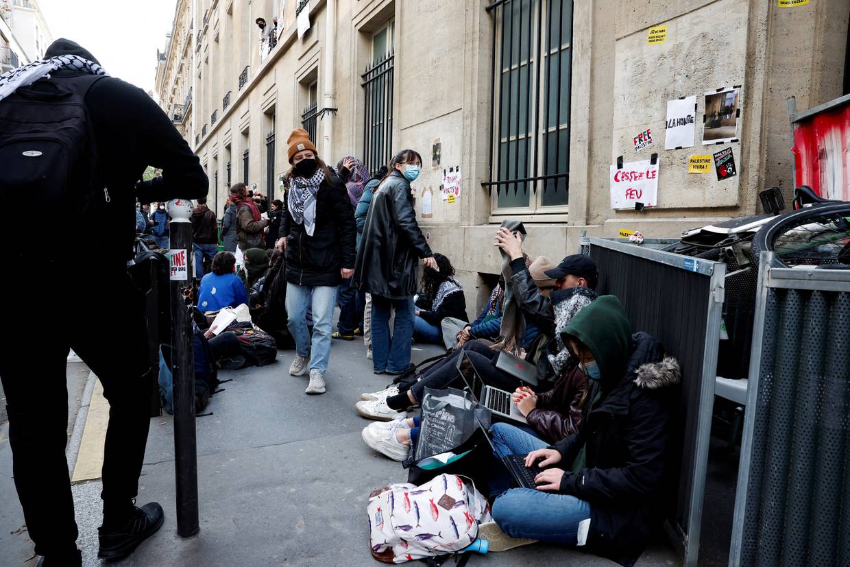 Jóvenes enmascarados participan en la ocupación de un edificio de la Universidad Sciences Po y bloquean la entrada en apoyo a los palestinos de Gaza, en París, Francia. 26 de abril de 2024. REUTERS/Benoit Tessier