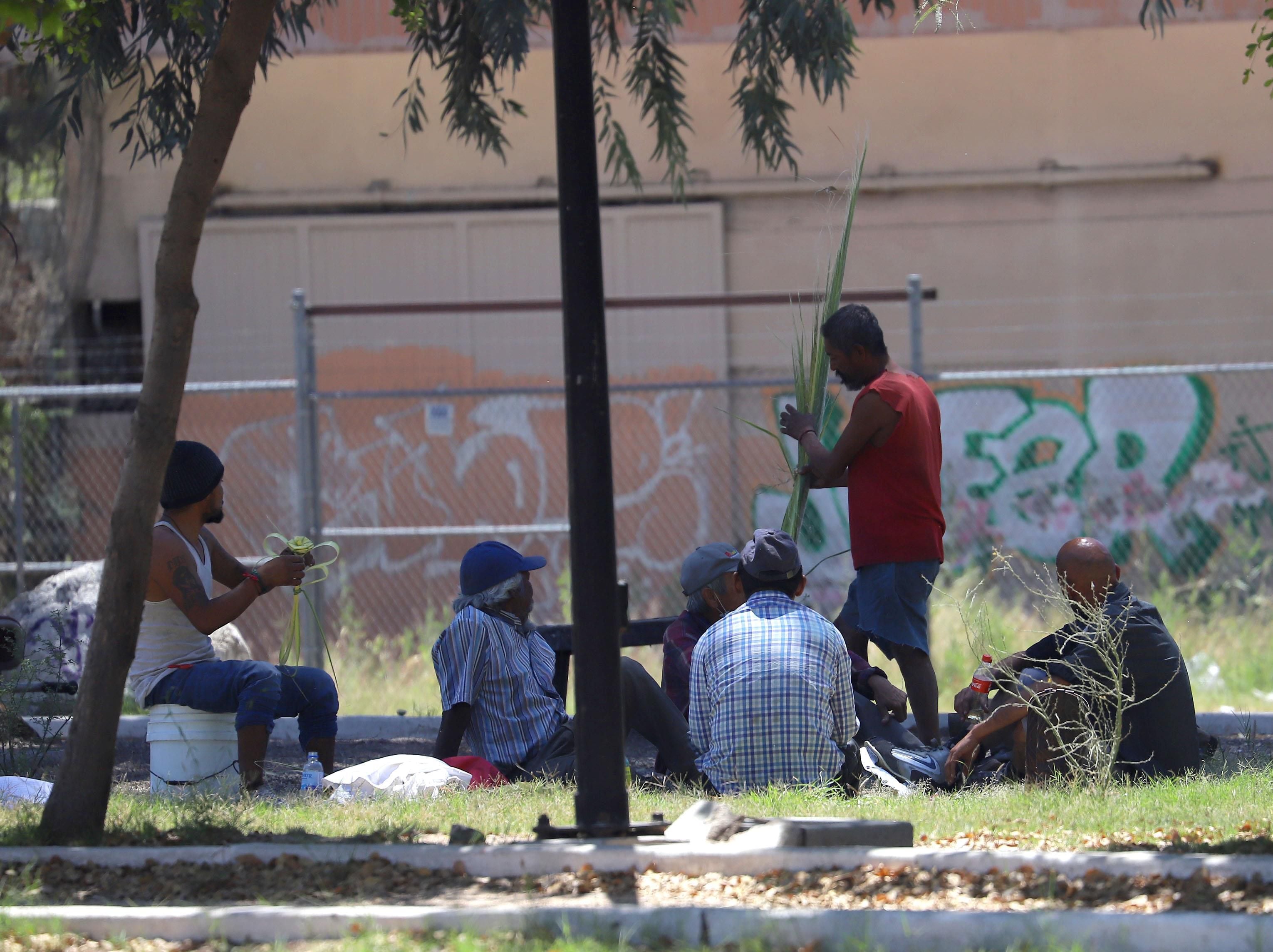 Personas en situación de calle en el camellón del bulevar Luis Encinas donde se reúnen a conversar y realizan figuras de palma que después venden a los automovilistas en los cruceros.