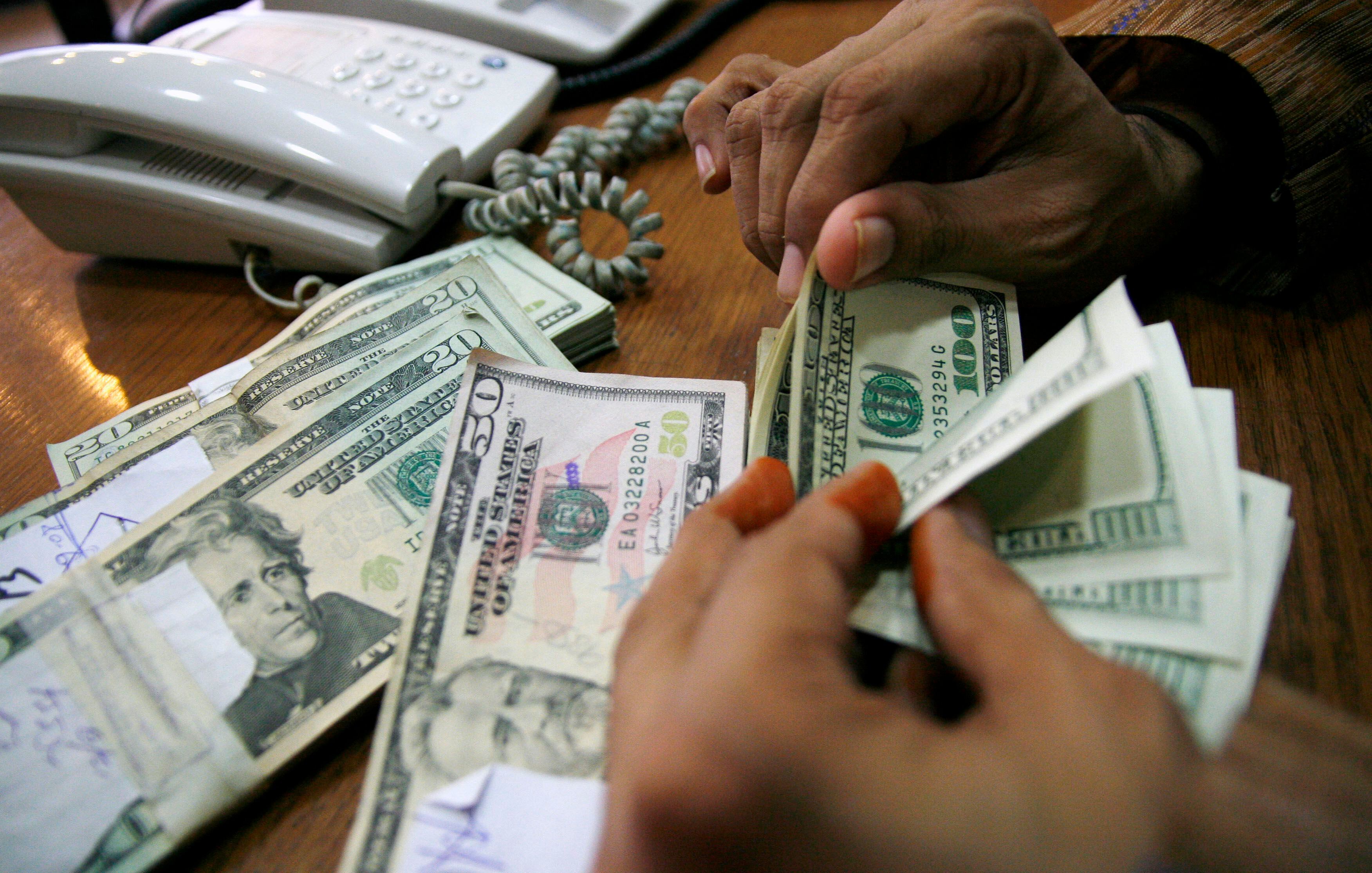 A Pakistani currency deader counts U.S. dollars at his shop in Karachi, Pakistan, Tuesday, Oct. 7, 2008. The rupee edged to a record low to the U.S. dollar during the last few minutes of interbank trade on Tuesday, weighed down by worsening economic fundamentals and unrelenting demand for dollars to cover imports. (AP Photo/Fareed Khan)