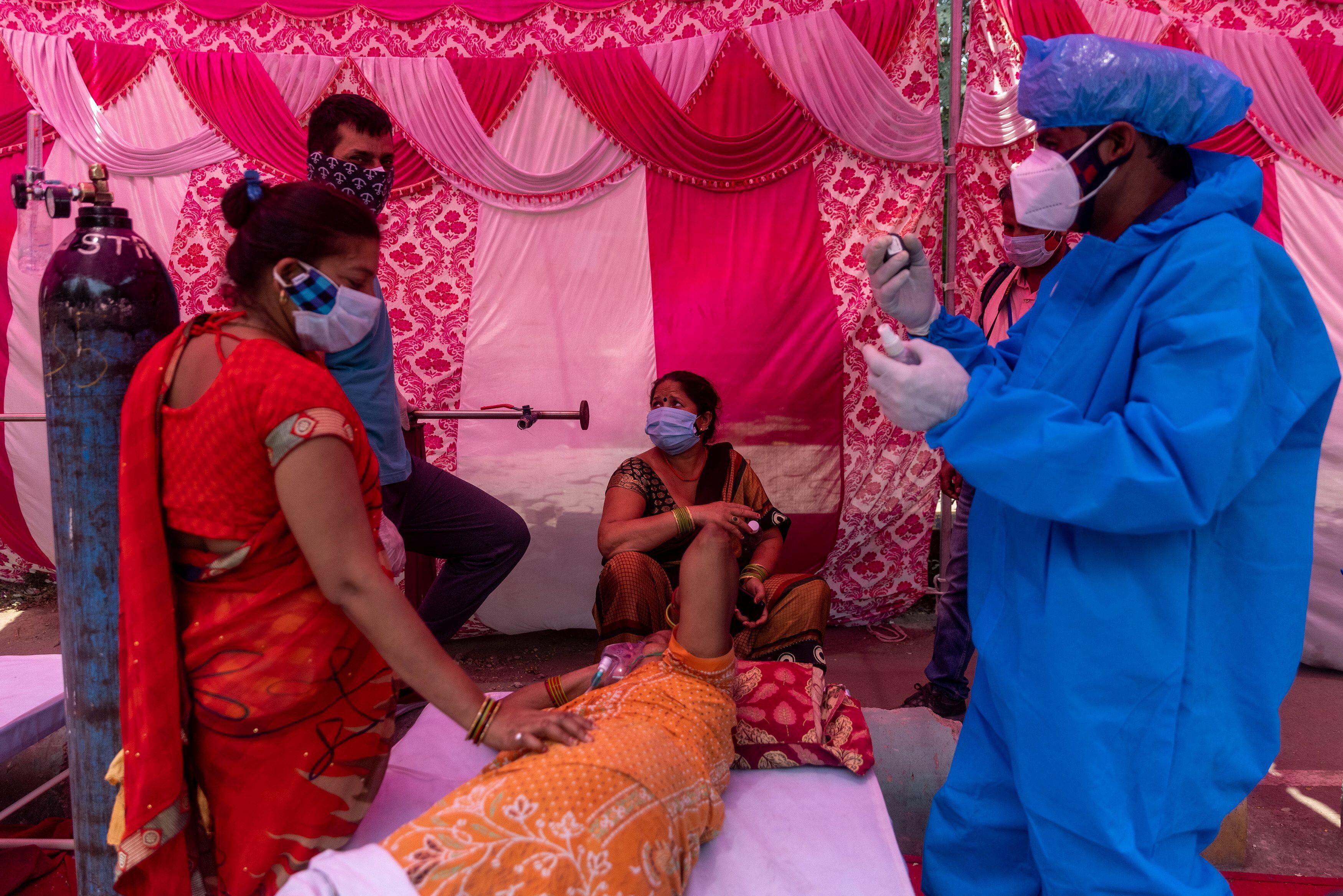 FOTO DE ARCHIVO: Una mujer rodeada por sus familiares recibe un suplemento de oxígeno en el templo sij de Gurudwara en Ghaziabad, India, el 6 de mayo de 2021. REUTERS/Danish Siddiqui