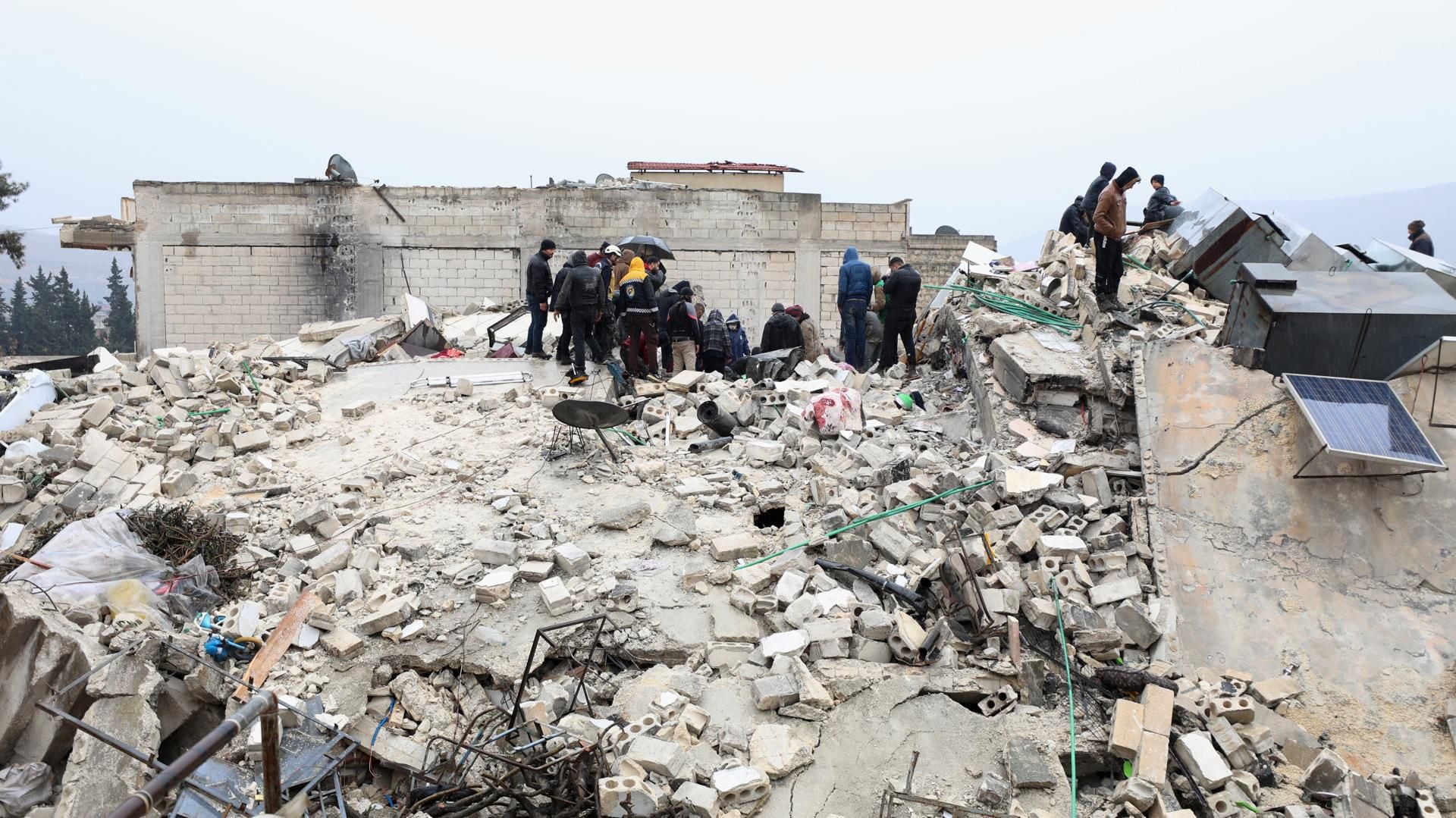 Un grupo de rescastistas fue registrado este lunes, 6 de febrero, al buscar sobrevivientes sobre los escombros de un edificio derrumbado, en la ciudad de Armanaz (Idlib, Siria), tras el fuerte terremoto que la vispera azotó a Siria y a Turquía. EFE/Yahya Nemah

