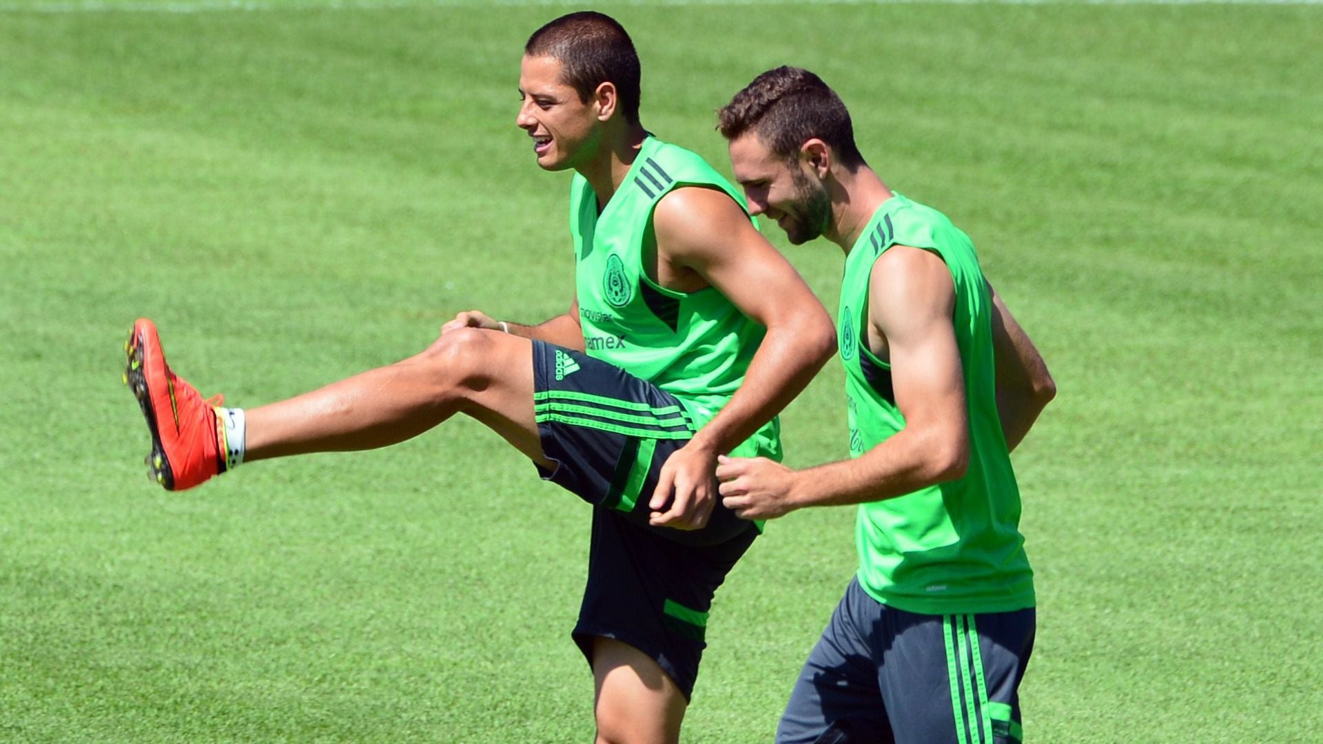 Mexico's forward Javier Hernandez (L) and defender Miguel Layun (R) stretch during a team training session at the Fortaleza University stadium in Fortaleza on June 28, 2014. Mexico will face Netherlands on June 29 for their Round of 16 match during their 2014 FIFA World Cup Brazil.   AFP PHOTO / Yuri CORTEZ