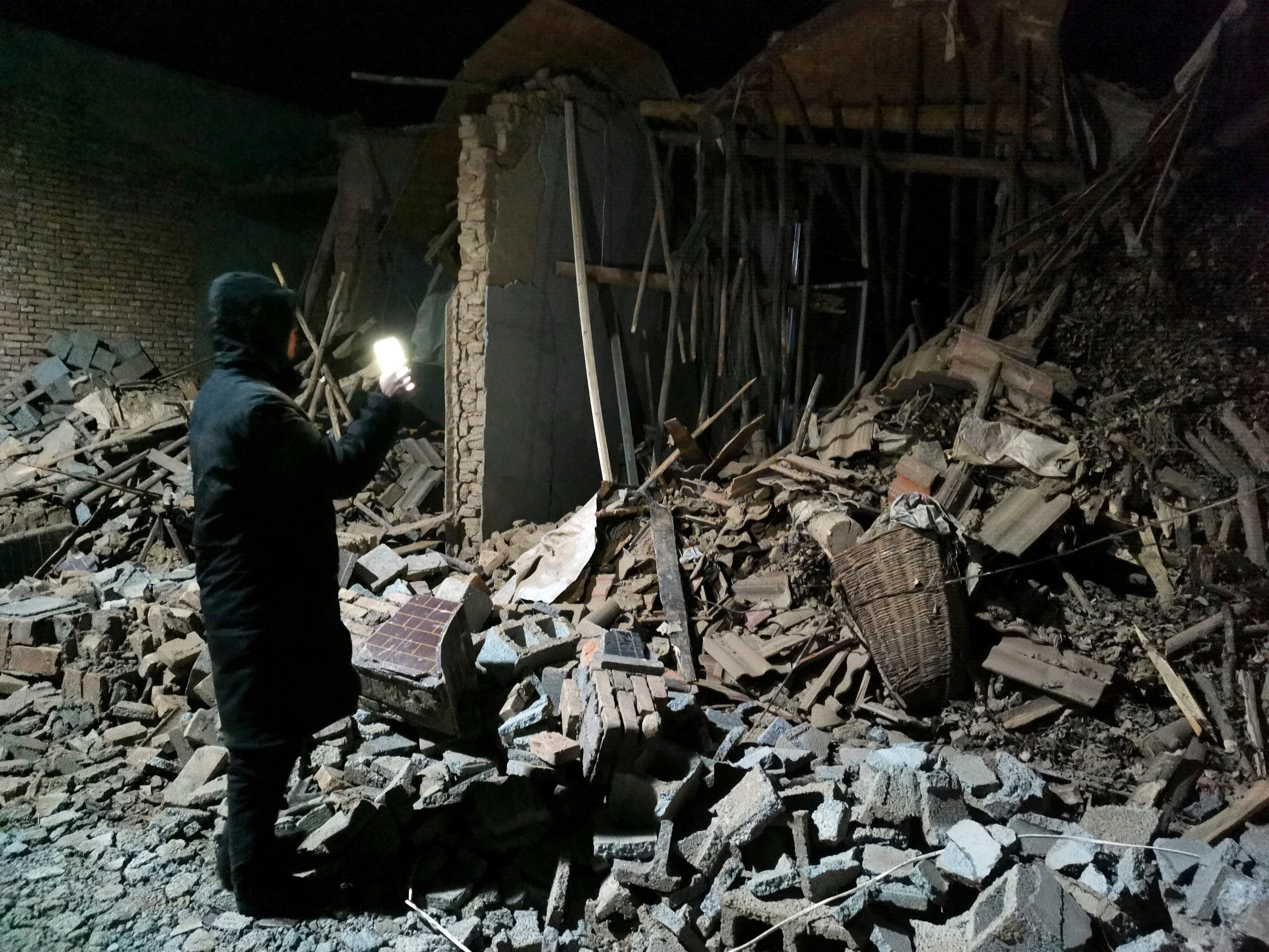Un empleado del gobierno busca entre los escombros de una casa que se derrumbó durante un sismo, el martes 19 de diciembre de 2023, en el condado de Jishishan, en la provincia de Gansú, en el noroeste de China. (Chinatopix Via AP)