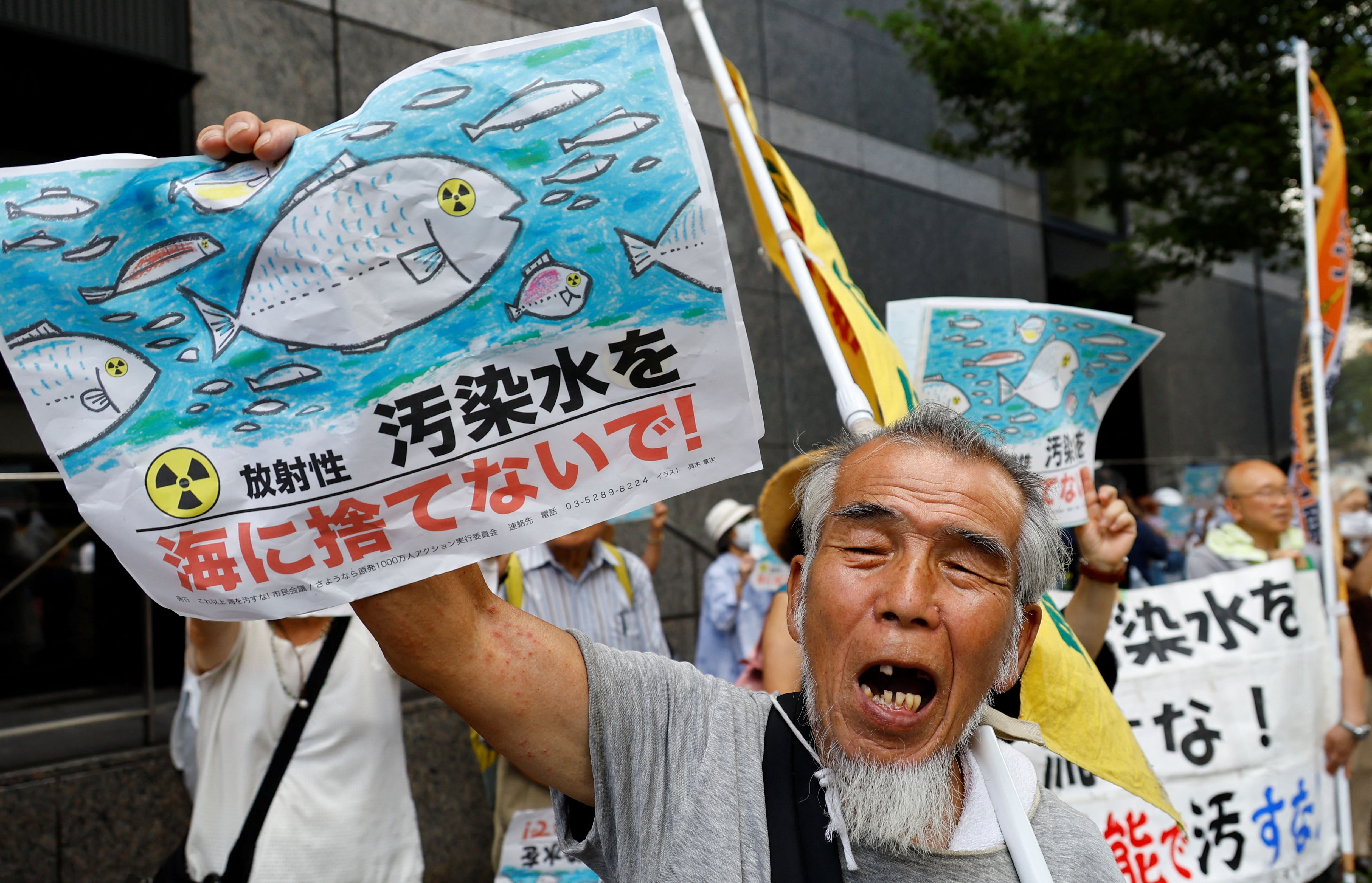 Un manifestante sostiene una pancarta en la que se lee "No al mar con agua contaminada con radiación" durante una concentración contra el plan de Japón de verter al océano agua radiactiva tratada procedente de la central nuclear de Fukushima Daiichi, destruida por el tsunami, frente a la sede de la Compañía Eléctrica de Tokio (TEPCO), operadora de la central nuclear, en Tokio, Japón. 24 de agosto de 2023. REUTERS/Kim Kyung-hoon