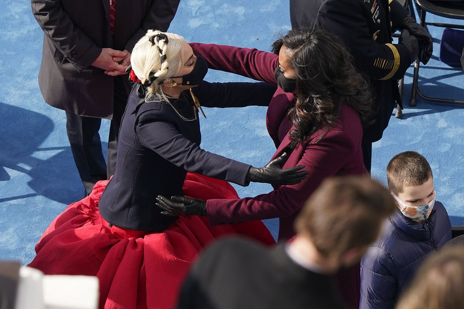 Lady Gaga y la ex primera dama Michelle Obama se abrazan después de asistir a la 59a ceremonia de investidura presidencial en el Capitolio en  Washington el miércoles 20 de enero de 2021. (Foto AP/Susan Walsh, Pool)