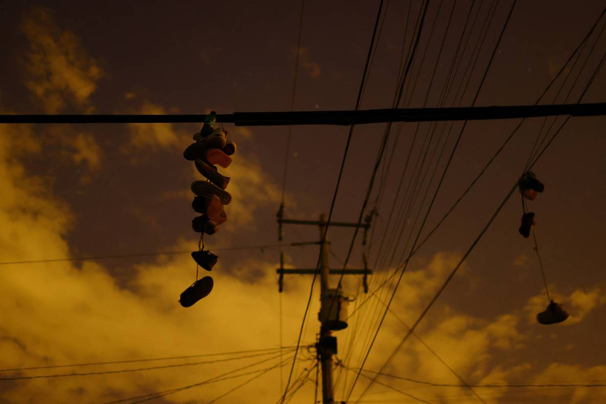 Imagen de archivo. Zapatos son vistos colgados de cables eléctricos en medio de un corte en la red eléctrica de México en un día de altas temperaturas, en Ciudad Juárez, México. 5 de julio de 2023. REUTERS/Jose Luis Gonzalez