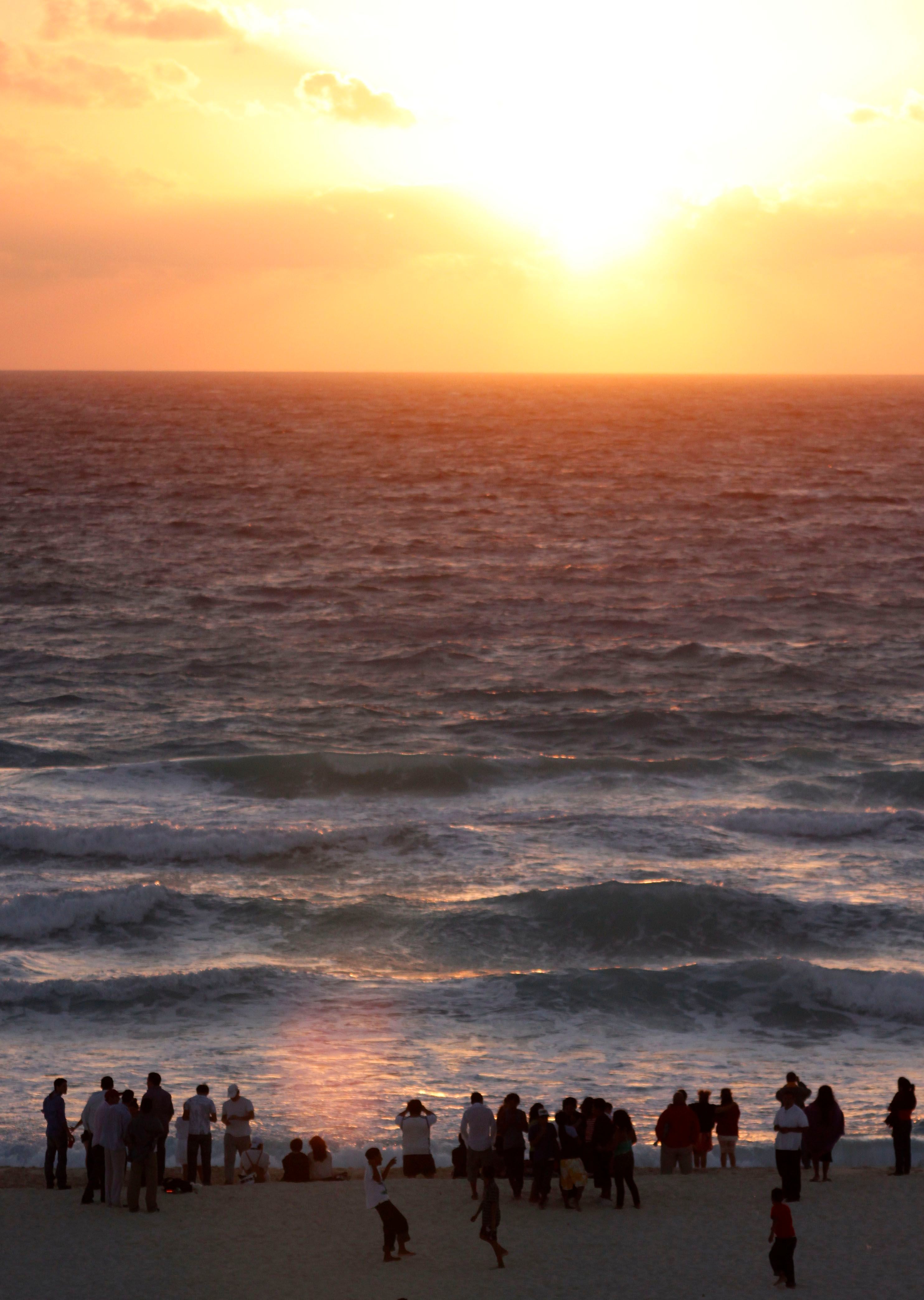 People watch the first sunrise of 2011 at a beach in Cancun, Mexico, Saturday, Jan. 1, 2011. (AP Photo/Israel Leal)