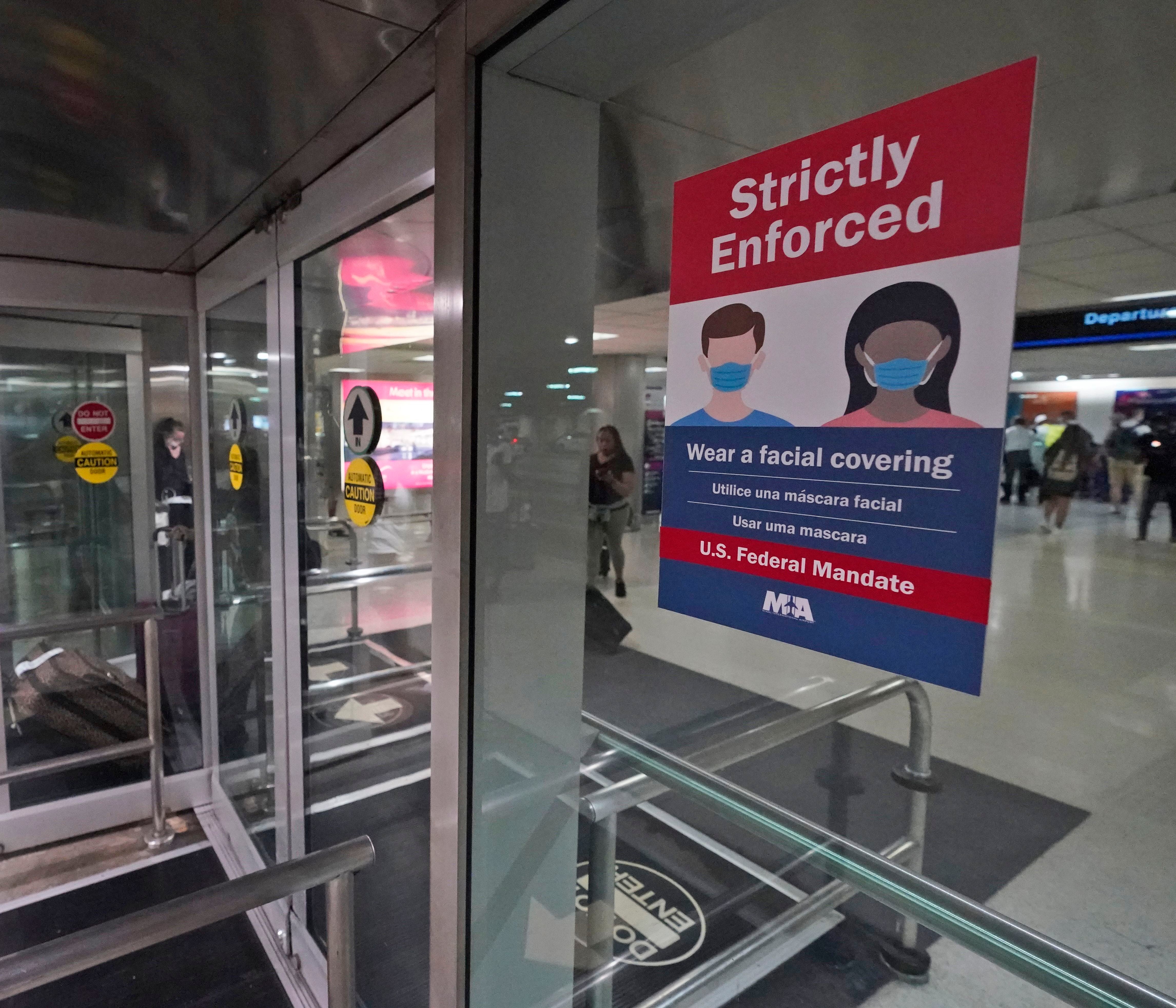Un letrero que indica el uso obligatorio de cubrebocas debido al coronavirus en la entrada del Aeropuerto Internacional de Miami, en Florida, el 28 de mayo de 2021. (AP Foto/Wilfredo Lee)