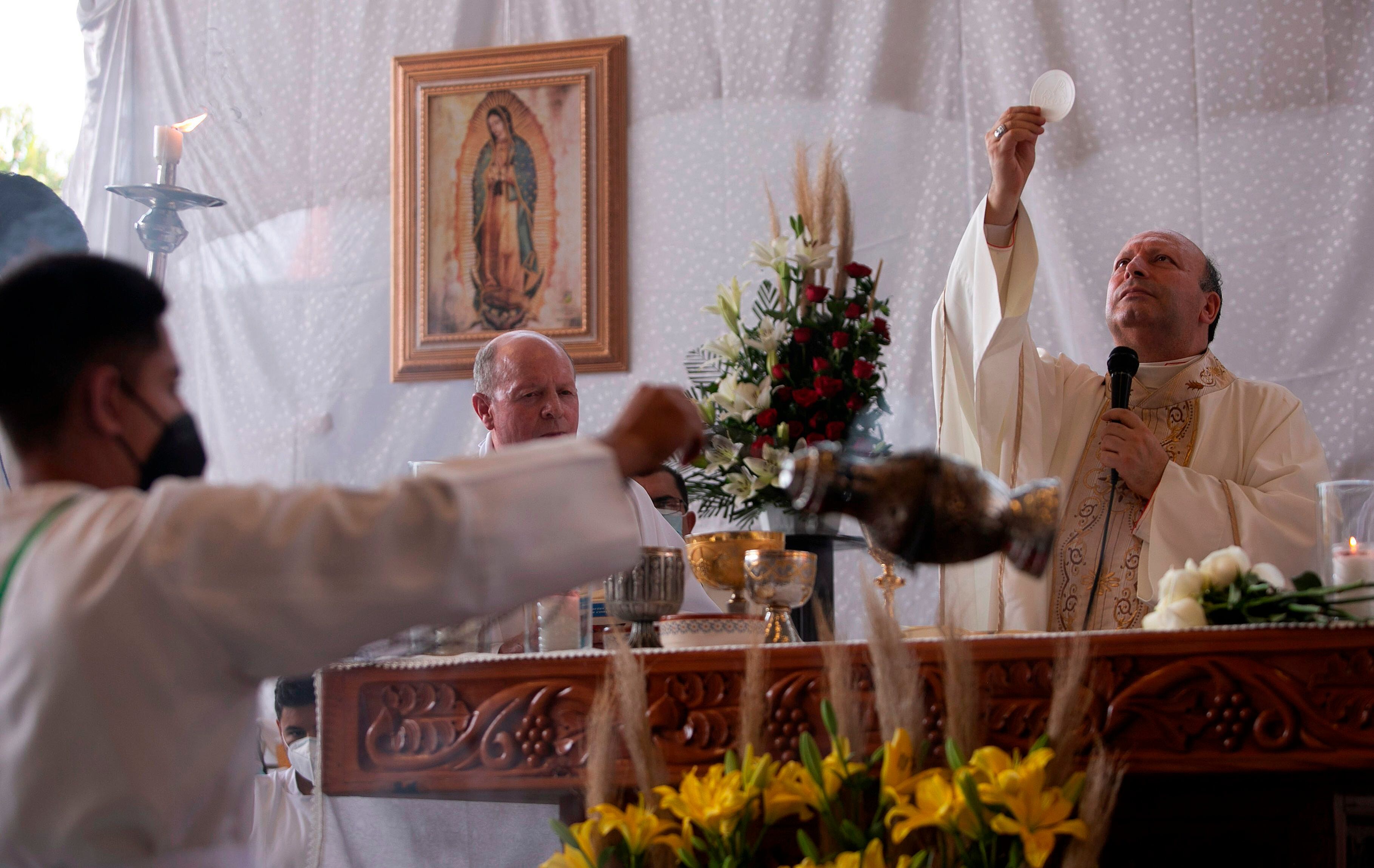 El nuncio apostólico Franco Coppola bendice hoy la hostia durante una misa para los habitantes de Aguililla, en el estado de Michioacán (México). EFE/Iván Villanueva

