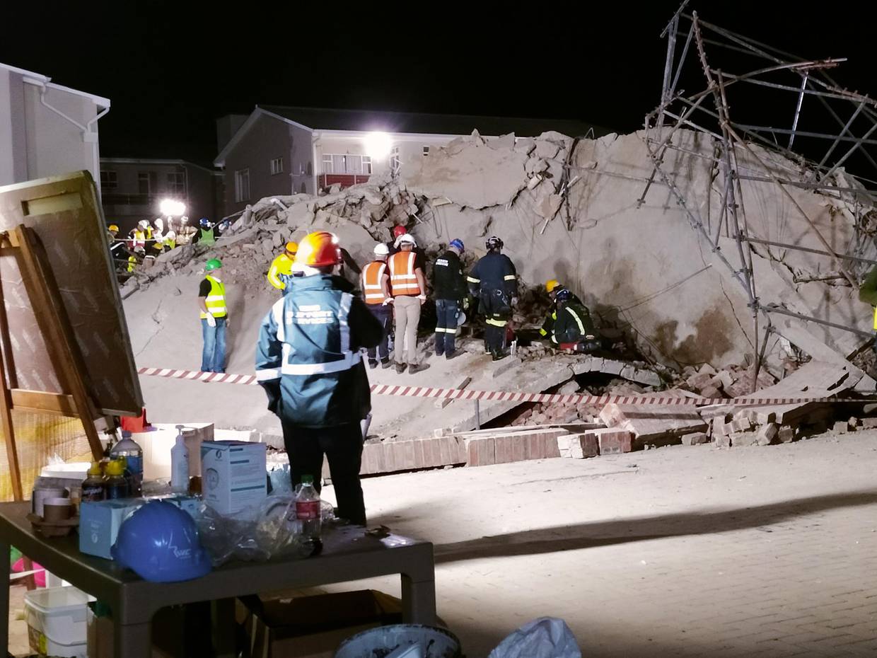 Emergency services try to locate the trapped construction workers who were trapped after a five-story building collapsed overnight in George, South Africa,