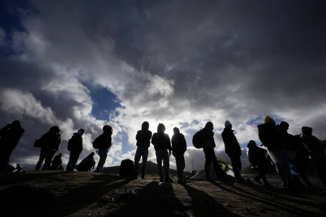Solicitantes de asilo esperan a ser procesados el viernes 2 de febrero de 2024 en un campamento improvisado cerca de Jacumba Hot Springs, California, luego de cruzar la frontera sur de Estados Unidos. (AP Foto/Gregory Bull)