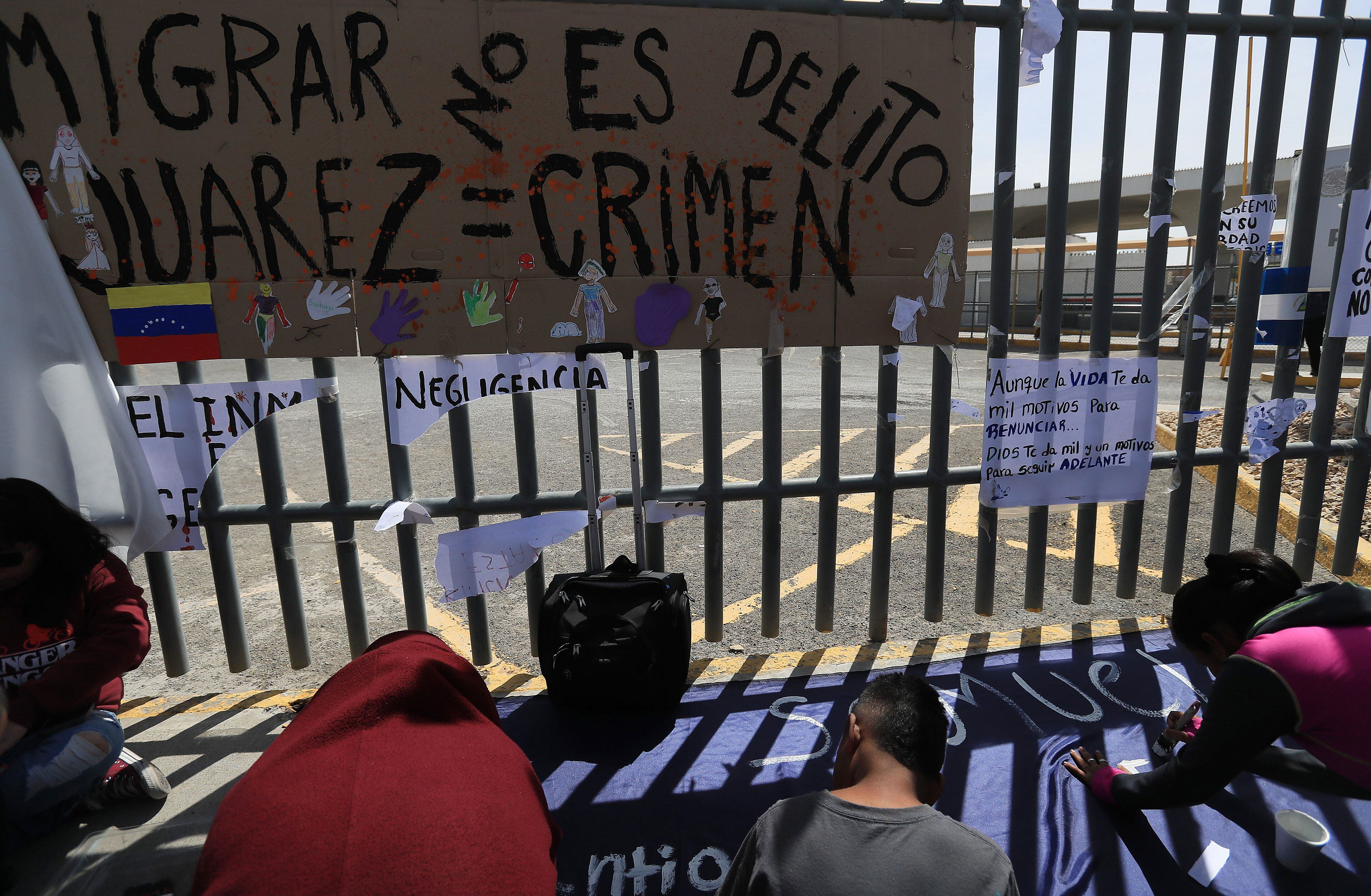 Migrantes escriben pancartas durante una manifestación para exigir justicia por 40 indocumentados que murieron por un incendio hace nueve días, hoy, al exterior del Instituto Nacional de Migración (INM), en Ciudad Juárez (México).  EFE/Luis Torres.
