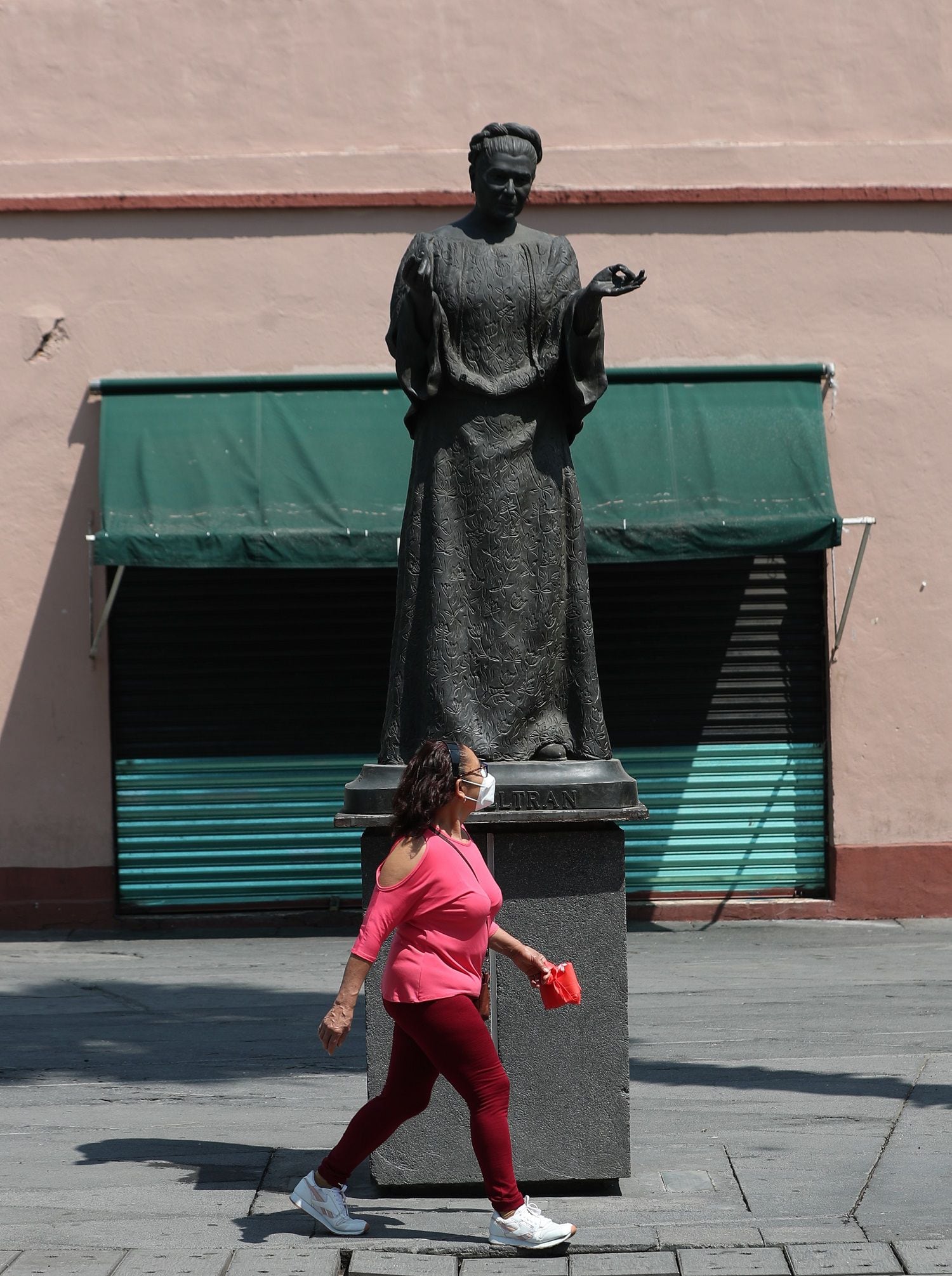 Una mujer camina hoy frente a la estatua de "Lola Beltrán", en la Plaza Garibaldi, en la Ciudad de México (México). EFE/ Mario Guzmán