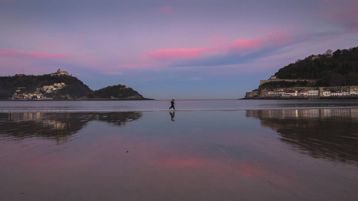 En la imagen de archivo, dos personas corren al amanecer por la orilla de la playa de La Concha de San Sebastián, España. EFE/Javier Etxezarreta