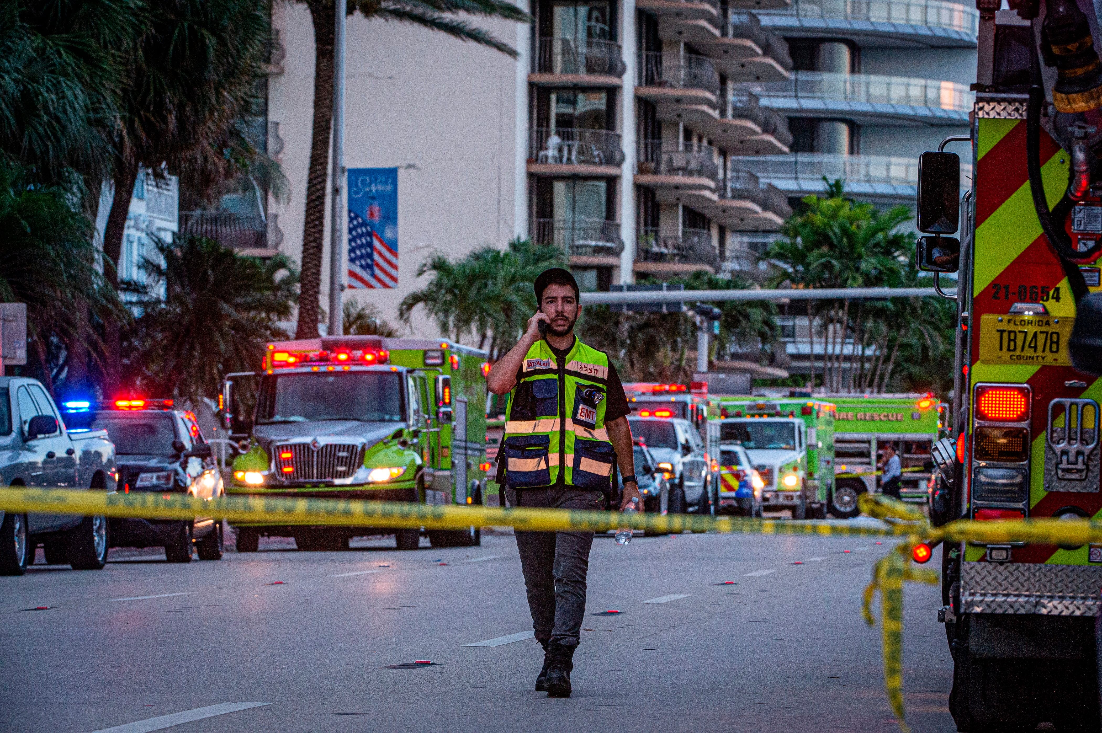 Un socorrista camina frente a varios camiones de bomberos cerca del edificio de 12 pisos parcialmente derrumbado hoy, cerca de 88th Street y Collins Avenue, en la ciudad de Surfside, al norte de Miami Beach, Florida, EE. UU., 24 de junio de 2021.EFE/ Giorgio Viera
