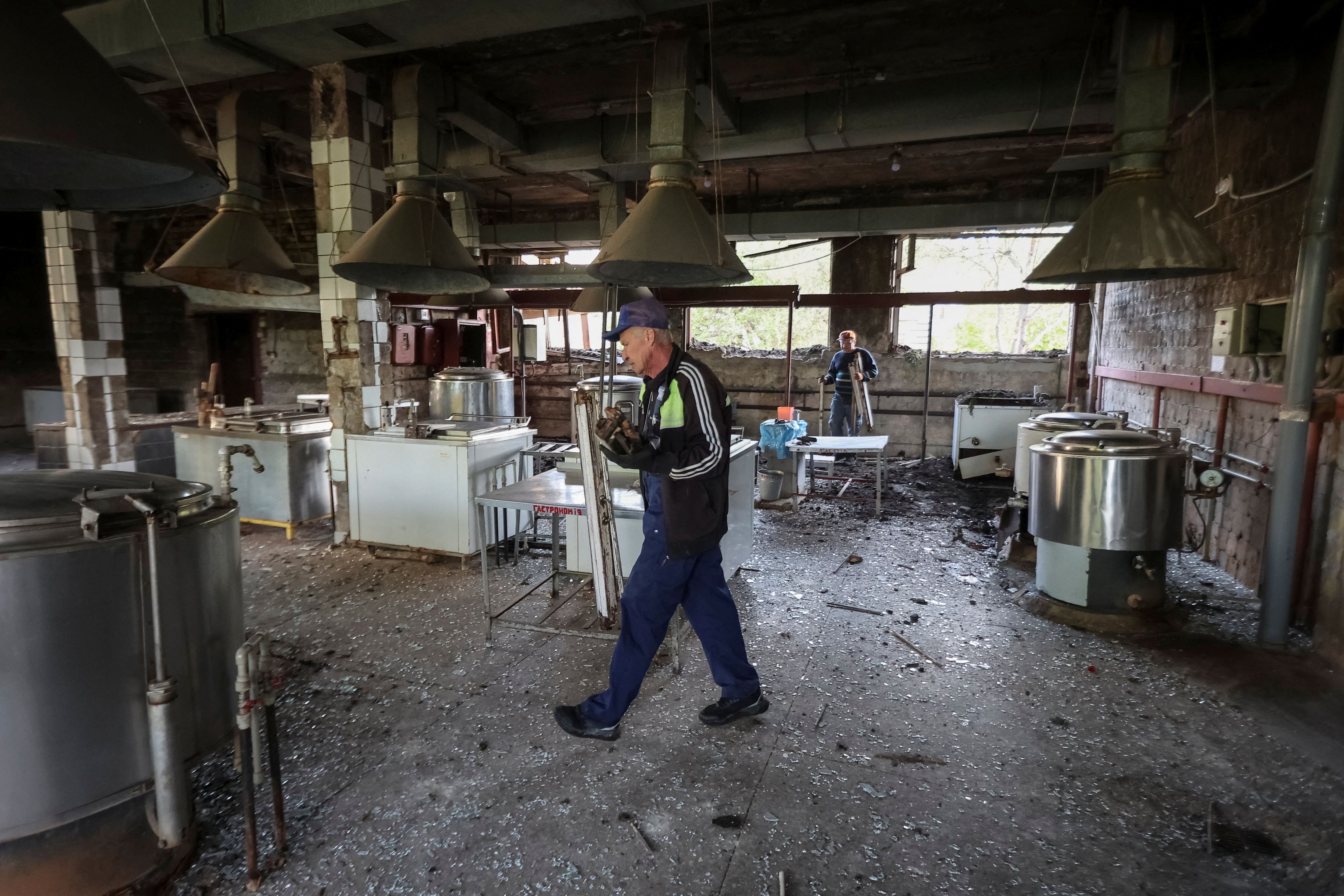 Trabajadores limpian una zona de cocina en un edificio hospitalario dañado por un ataque con misiles rusos en Jarkov | FOTO REUTERS/Vyacheslav Madiyevskyy
