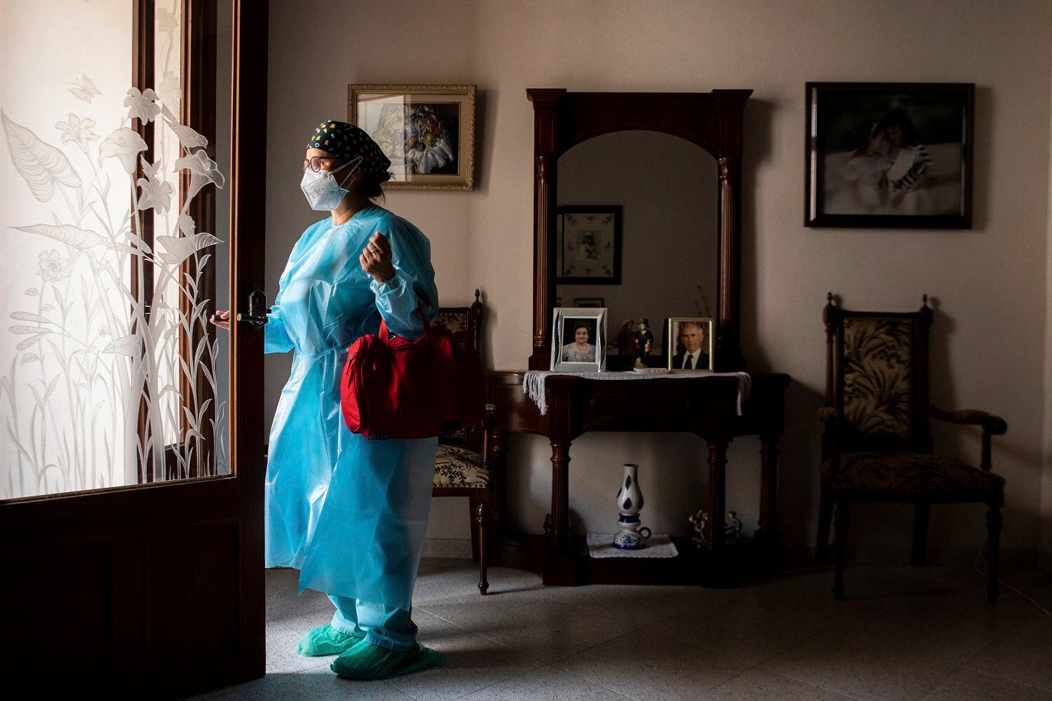 La enfermera Pilar Rodríguez abandona la casa de su paciente Antonia Crespi, de 93 años, en la localidad de Sa Pobla, en la isla española de Mallorca, el 30 de abril de 2021. (AP Foto/Francisco Ubilla)