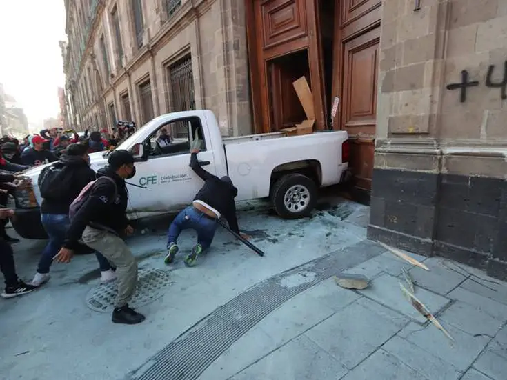 Normalistas de Ayotzinapa utilizan camioneta de CFE para derribar puerta de Palacio Nacional 