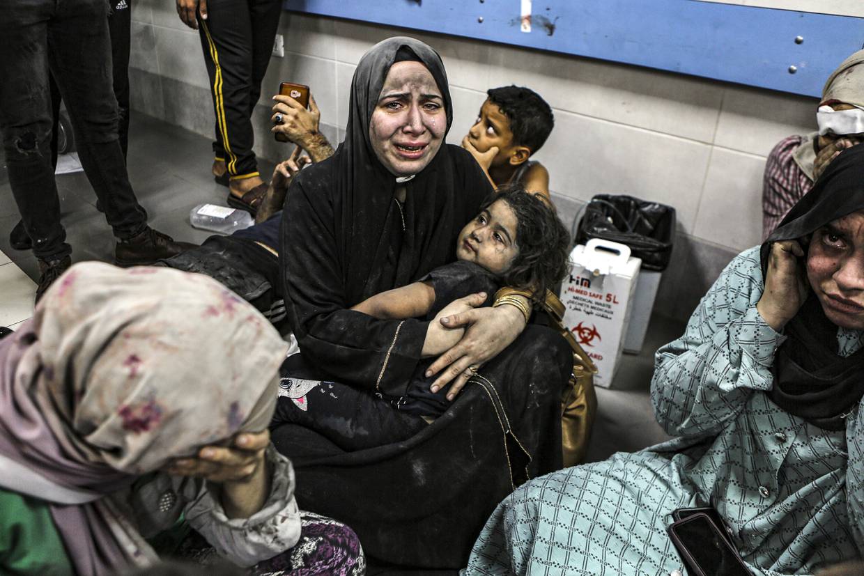 Palestinos heridos por un ataque contra el hospital Ahli Arab sentados en el piso del hospital Al Shifa, en Gaza, Franja de Gaza, el martes 17 de octubre de 2023. (AP Foto/Abed Khaled)