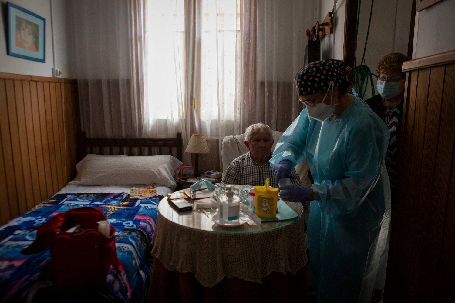 La enfermera Pilar Rodríguez pone la vacuna contra el coronavirus a Martín Gomila Serra, de 82 años, en su casa en la localidad de Sa Pobla, en la isla española de Mallorca, el 30 de abril de 2021. (AP Foto/Francisco Ubilla)