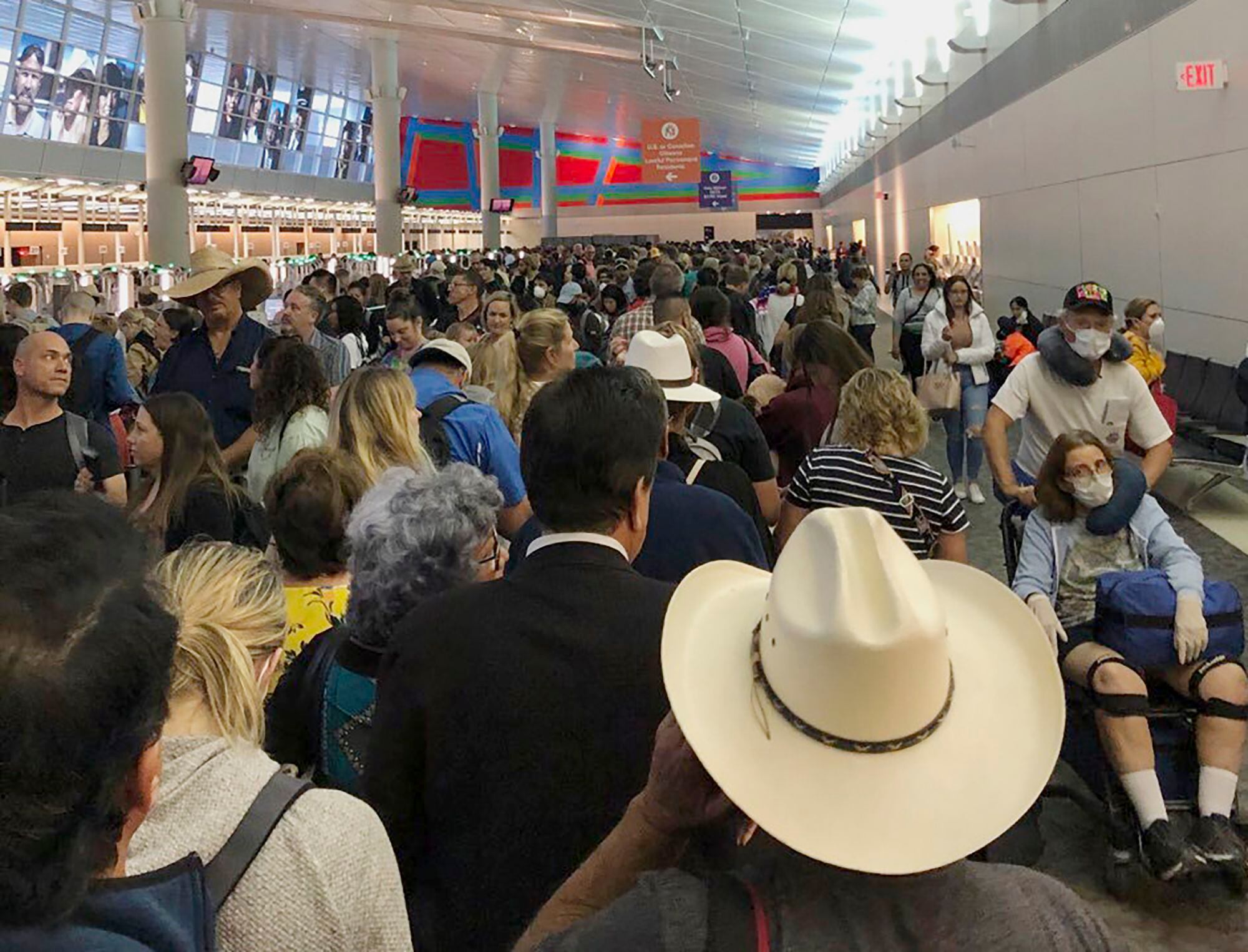En esta imagen proporcionada por Austin Boschen, gente esperando a pasar la aduana en el Aeropuerto Internacional de Dallas Fort Worth en Grapevine, Texas, el sábado 14 de marzo de 2020. Saturday, March 14, 2020. (Austin Boschen via AP)