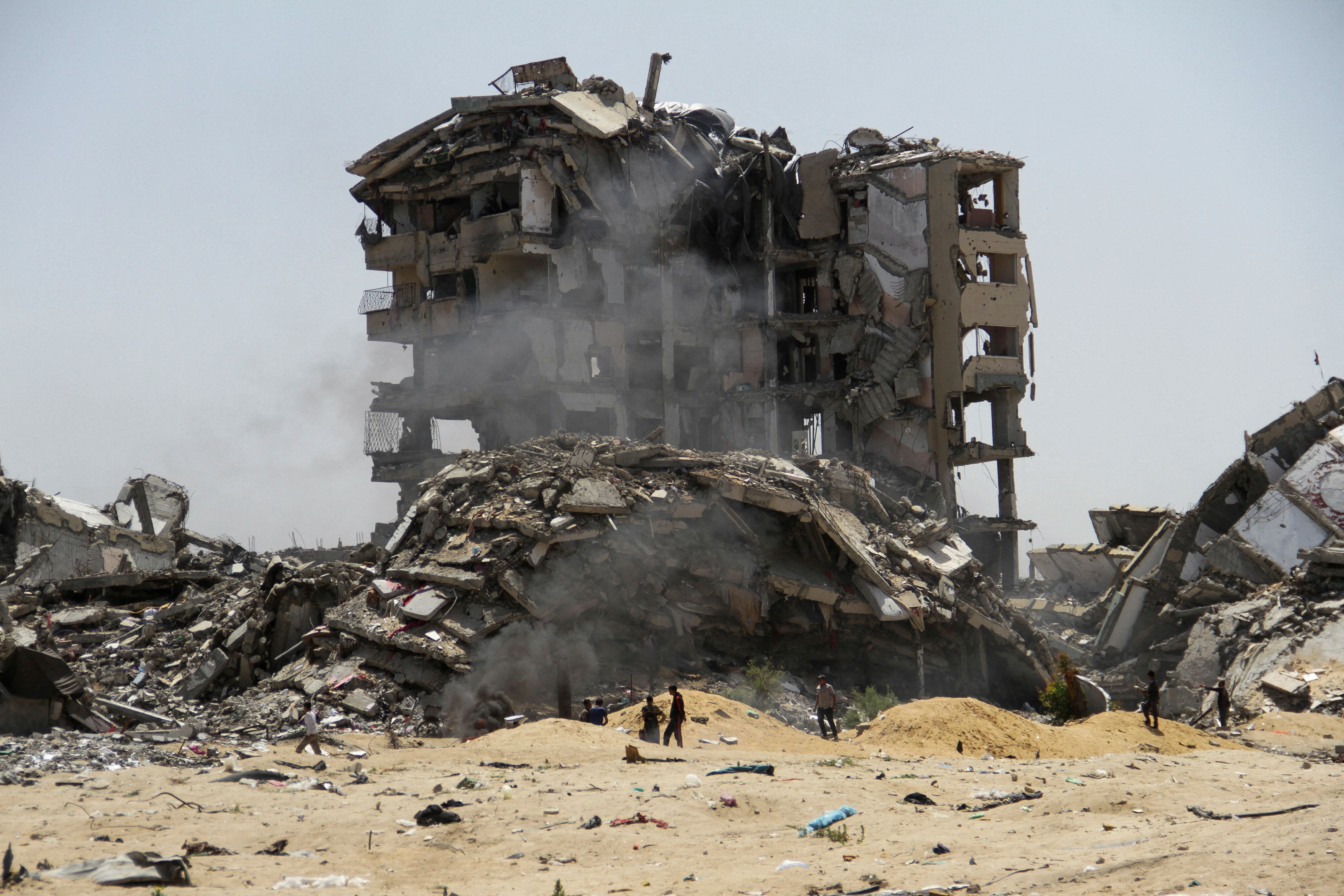 Palestinos caminan junto a los escombros de edificios residenciales destruidos por ataques israelíes, en medio del actual conflicto entre Israel y Hamás, en el norte de la Franja de Gaza. 22 de abril de 2024. REUTERS/Mahmoud Issa.