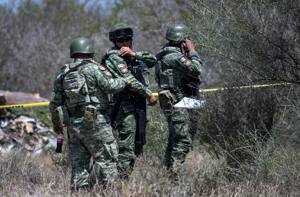 Integrantes del Ejército Mexicano resguardan este jueves la zona donde se localizaron cinco restos humanos en el municipio de Pesquería (México). EFE/Miguel Sierra