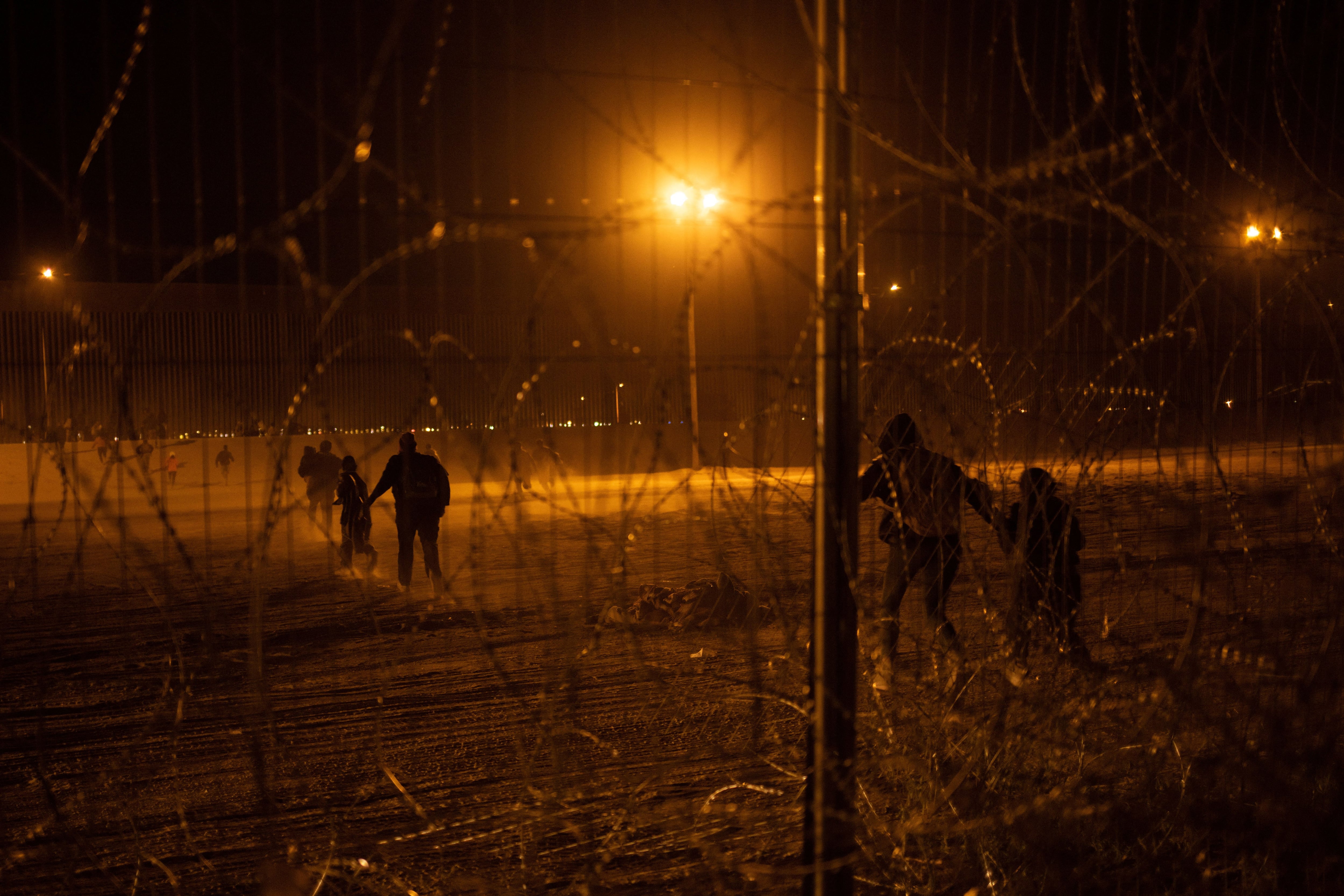 FOTO DE ARCHIVO: Migrantes corren hacia el muro fronterizo después de romper una valla de alambre de púas desde la orilla del río Grande después de cruzar de Ciudad Juárez, México a El Paso, Texas, Estados Unidos, 3 de abril de 2024.  REUTERS/Adrees Latif/Foto de archivo