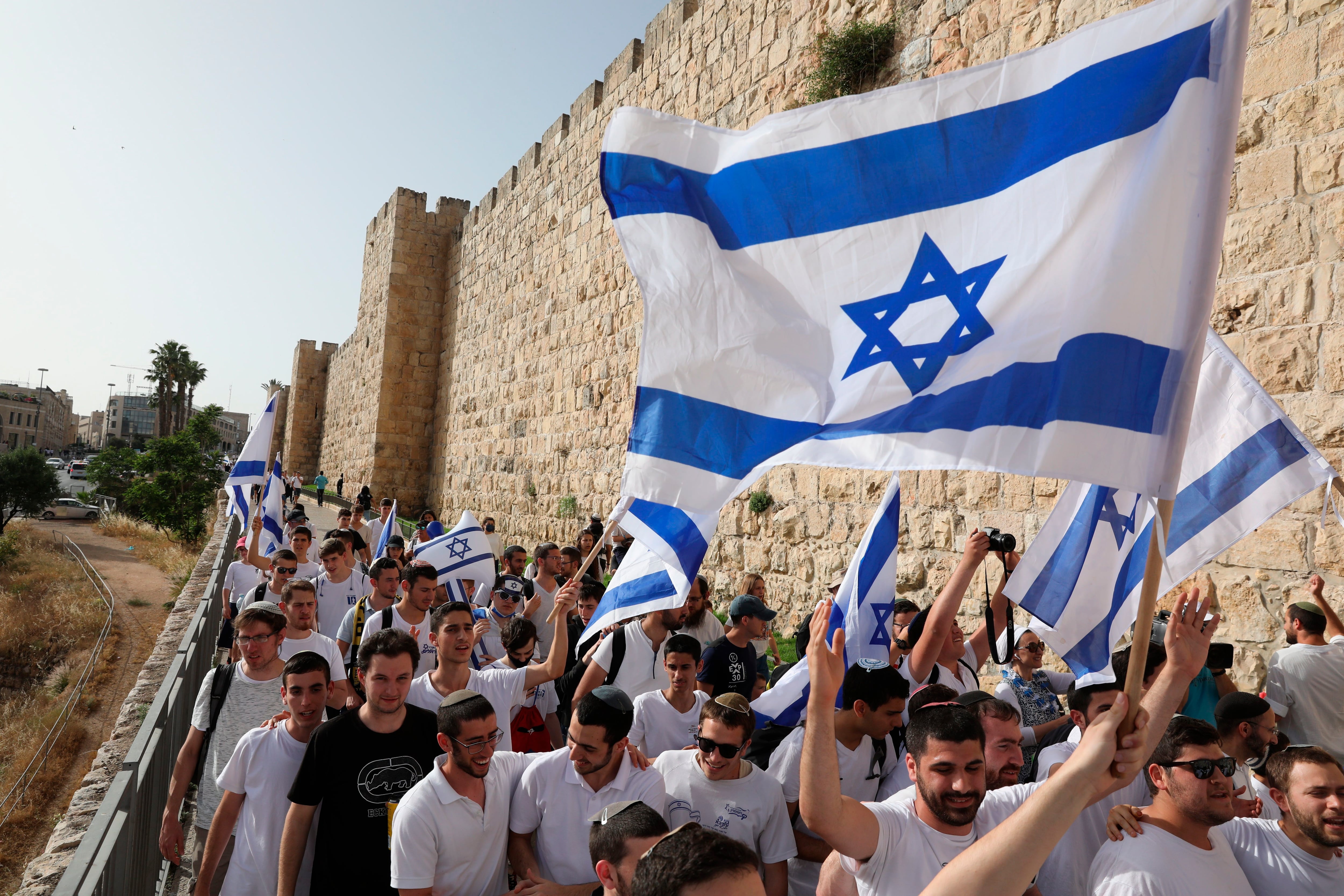 Varios israelíes se manifiestan con banderas del país este lunes en la ciudad vieja de Jerusalén. La tensión es alta en Jerusalén tras días de choques entre palestinos y la Policía israelí, que hoy podría aumentar por la conmemoración del Día de Jerusalén, en el que los israelíes celebran la reunificación de la ciudad en 1967 y que para los palestinos supuso el inicio de la ocupación.EFE/ABIR SULTAN
