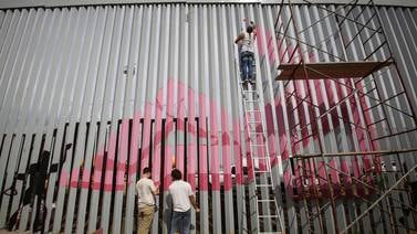 Artistas de Tijuana pintan de nuevo muro fronterizo como protesta tras renovación de EU